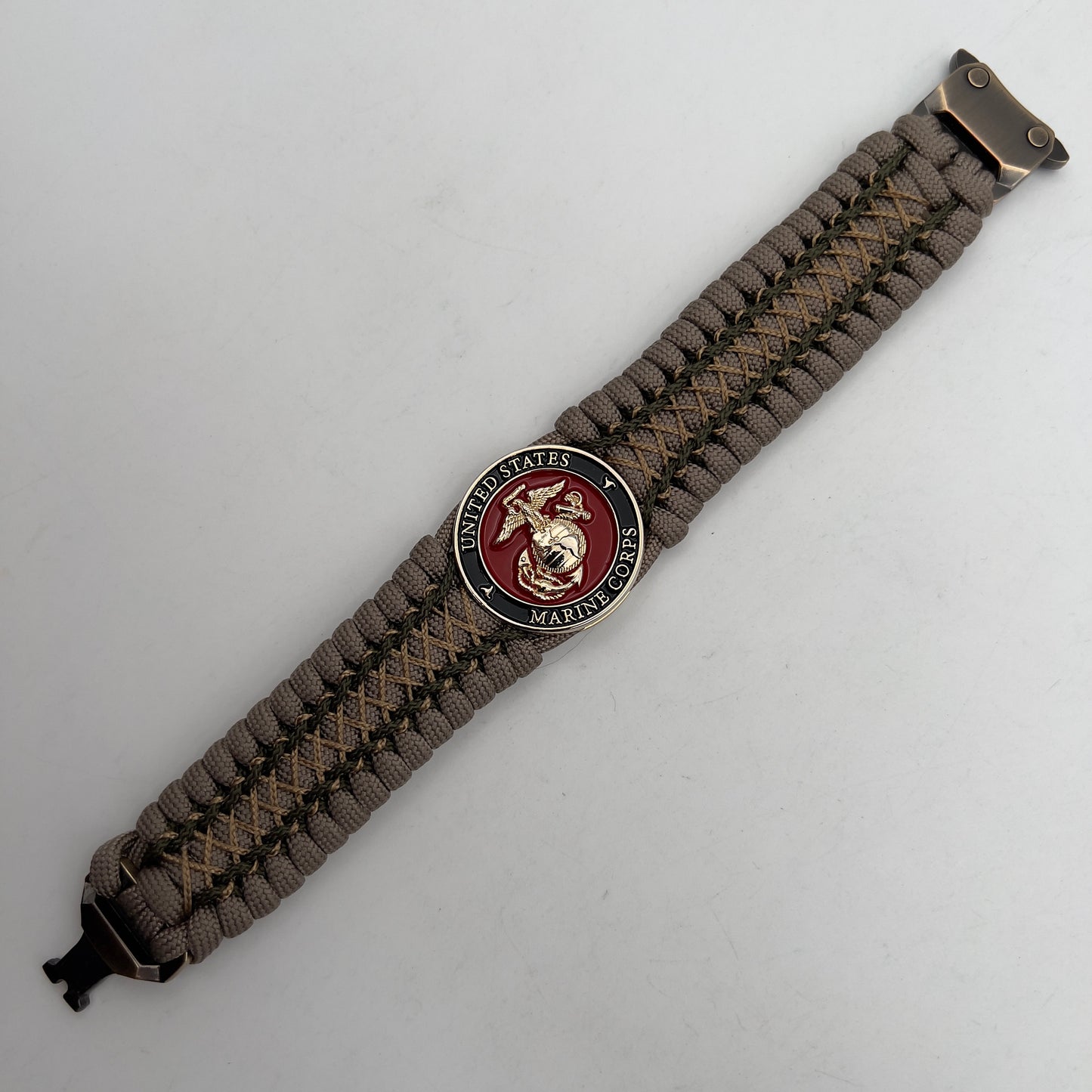 Thick, wide, rigid and comfortable braided United States Marine Corps bracelet featuring a 24K gold plated USMC Eagle Globe and Anchor medallion, a gold Cobra style tactical buckle and woven with tan 550 paracord and olive drab micro and tan nano cord.