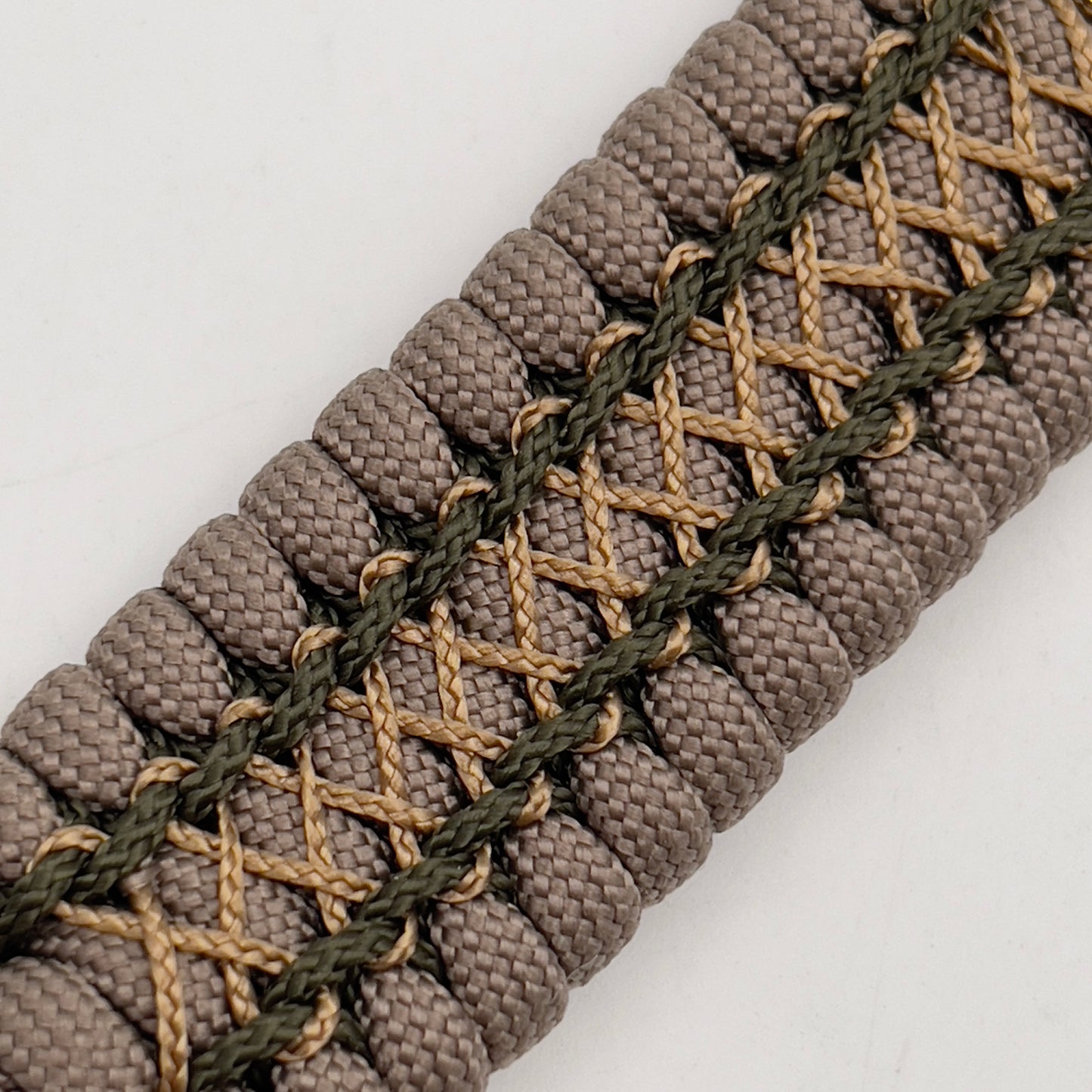 Thick, wide, rigid and comfortable braided United States Marine Corps bracelet featuring a 24K gold plated USMC Eagle Globe and Anchor medallion, a gold Cobra style tactical buckle and woven with tan 550 paracord and olive drab micro and tan nano cord.
