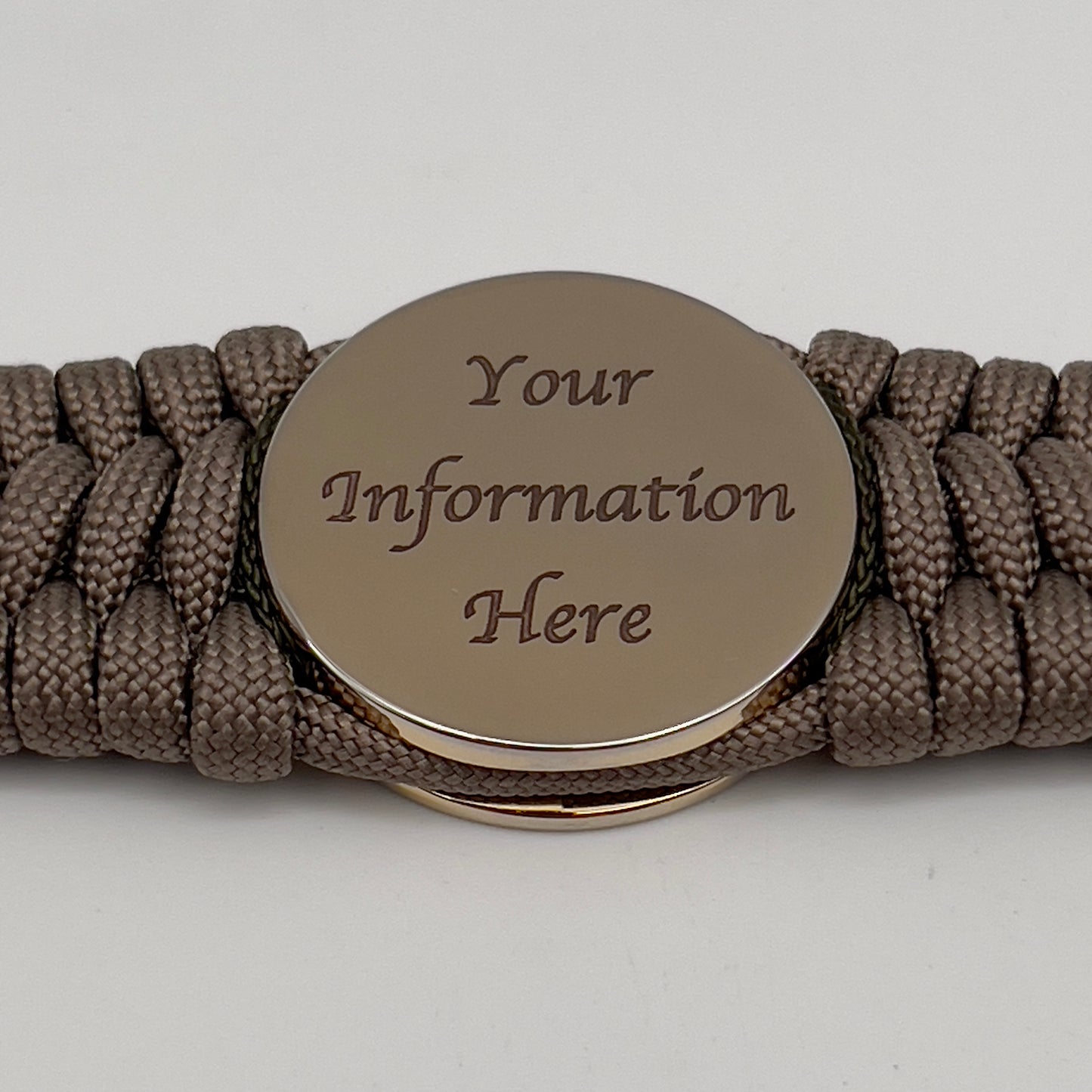 Thick, wide, rigid and comfortable braided United States Marine Corps bracelet featuring a 24K gold plated USMC Eagle Globe and Anchor medallion, a gold Cobra style tactical buckle and woven with tan 550 paracord and olive drab micro and tan nano cord.