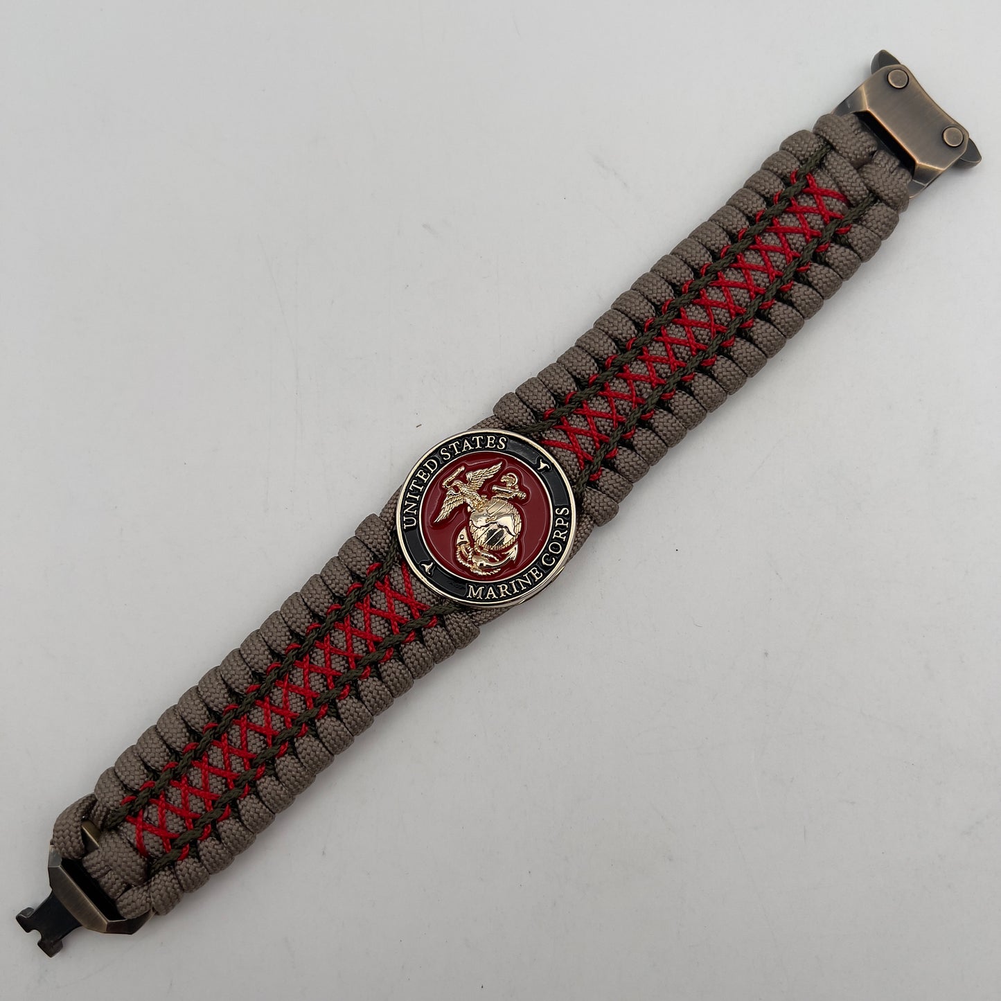 Thick, wide, rigid and comfortable braided United States Marine Corps bracelet featuring a 24K gold plated USMC Eagle Globe and Anchor medallion, a gold Cobra style tactical buckle and woven with tan 550 paracord, olive drab micro and Imperial red nano cord.