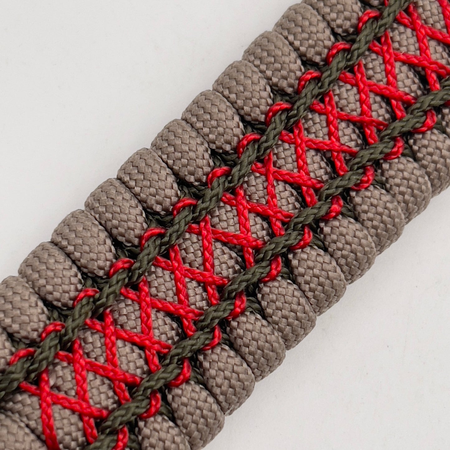 Thick, wide, rigid and comfortable braided United States Marine Corps bracelet featuring a 24K gold plated USMC Eagle Globe and Anchor medallion, a gold Cobra style tactical buckle and woven with tan 550 paracord, olive drab micro and Imperial red nano cord.