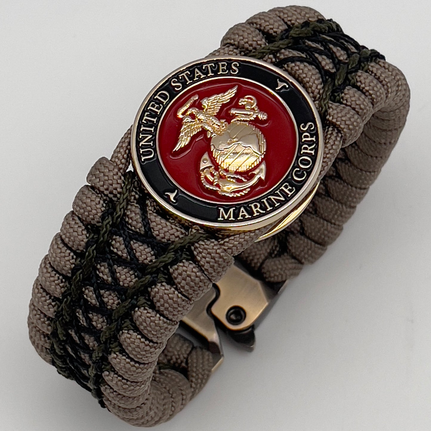 Thick, wide, rigid and comfortable braided United States Marine Corps bracelet featuring a 24K gold plated USMC Eagle Globe and Anchor medallion, a gold Cobra style tactical buckle and woven with tan 550 paracord, olive drab micro and black nano cord.