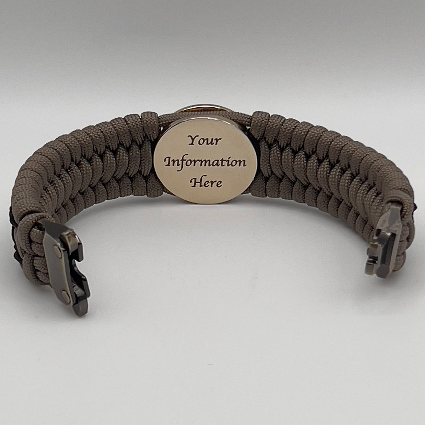 Thick, wide, rigid and comfortable braided United States Marine Corps bracelet featuring a 24K gold plated USMC Eagle Globe and Anchor medallion, a gold Cobra style tactical buckle and woven with tan 550 paracord and black nano and micro cord.