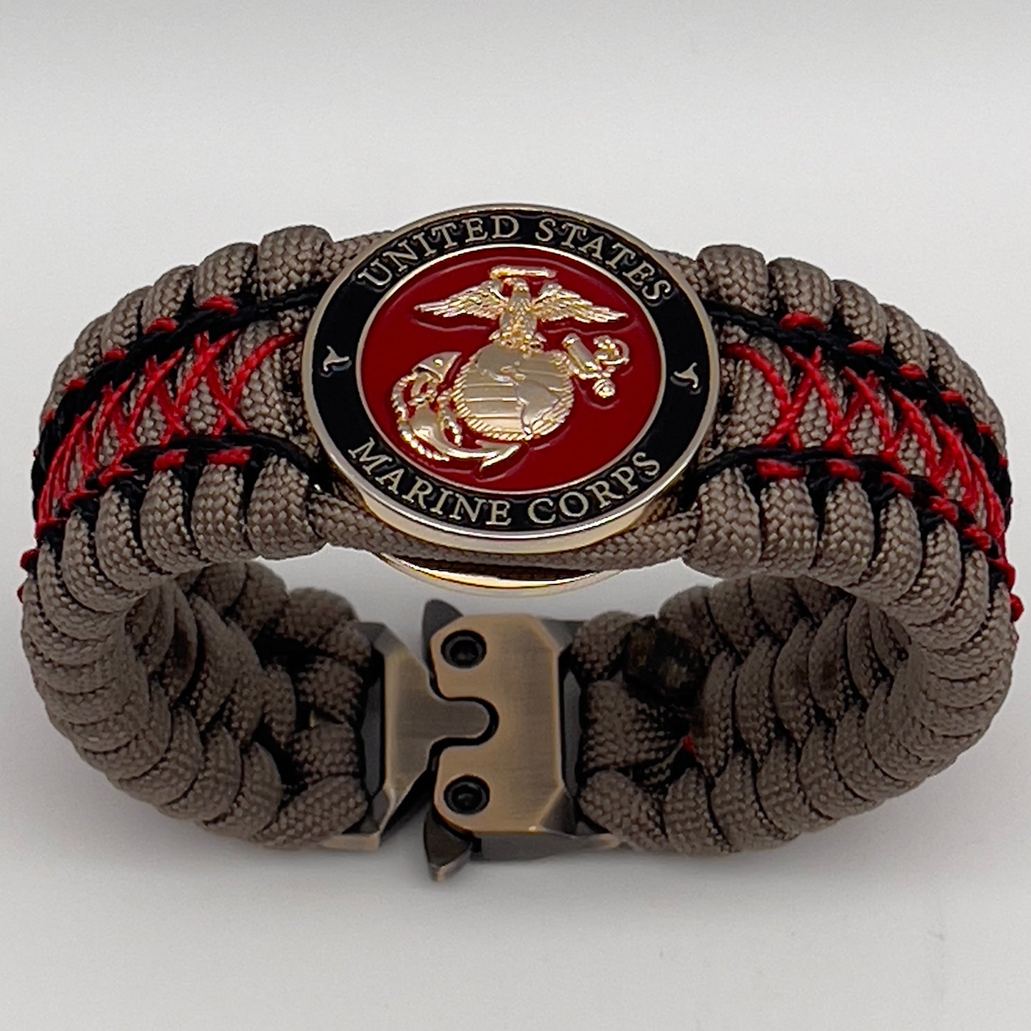 Thick, wide, rigid and comfortable handwoven United States Marine Corps bracelet featuring a 24K gold plated USMC Eagle Globe and Anchor medallion, a gold Cobra style tactical buckle and woven with tna 550 paracord, black micro cord and red nano cord.