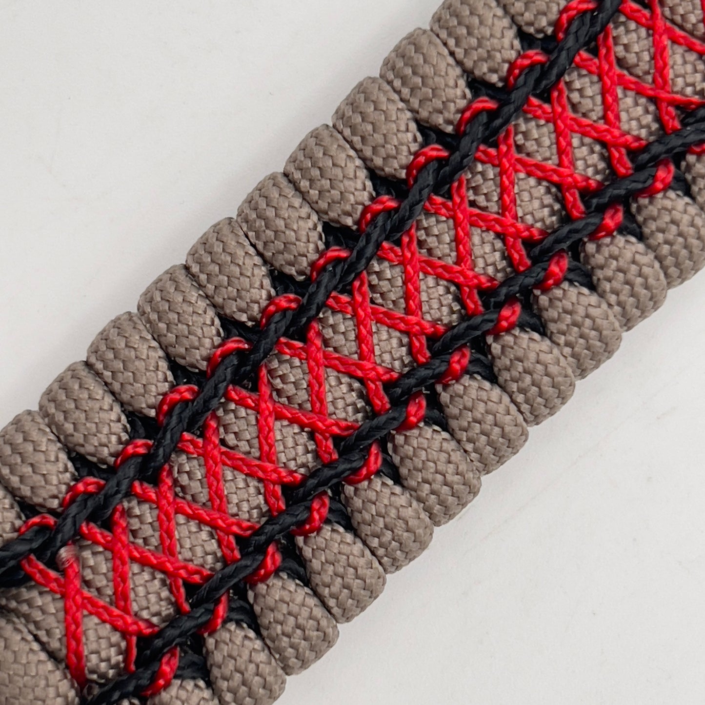 Thick, wide, rigid and comfortable handwoven United States Marine Corps bracelet featuring a 24K gold plated USMC Eagle Globe and Anchor medallion, a gold Cobra style tactical buckle and woven with tna 550 paracord, black micro cord and red nano cord.