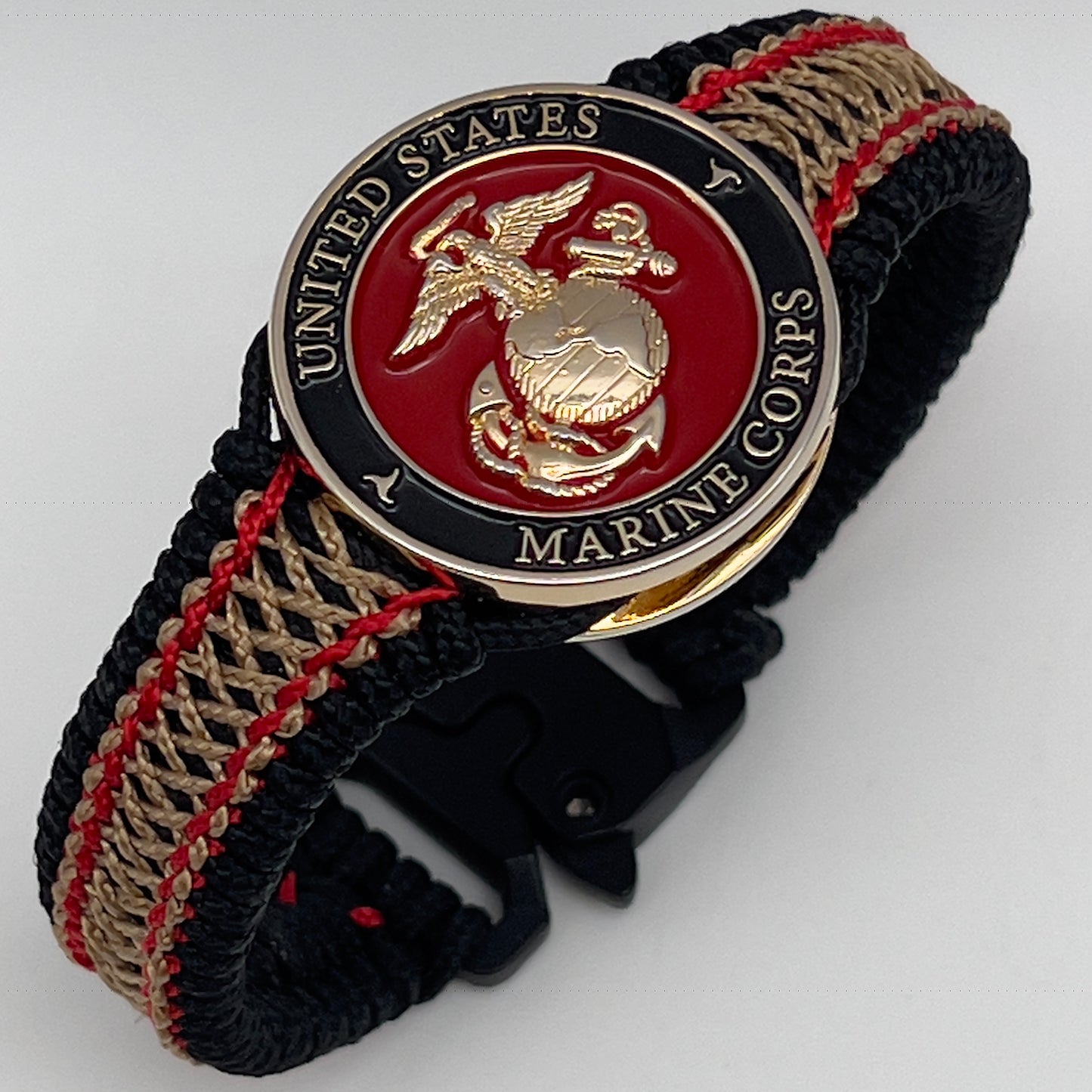Thin, narrow, flexible and comfortable braided United States Marine Corps bracelet featuring a 24K gold plated USMC Eagle Globe and Anchor medallion, a black Cobra style tactical buckle and woven with black Type-1 paracord and Imperial Red and Gold nano cord.