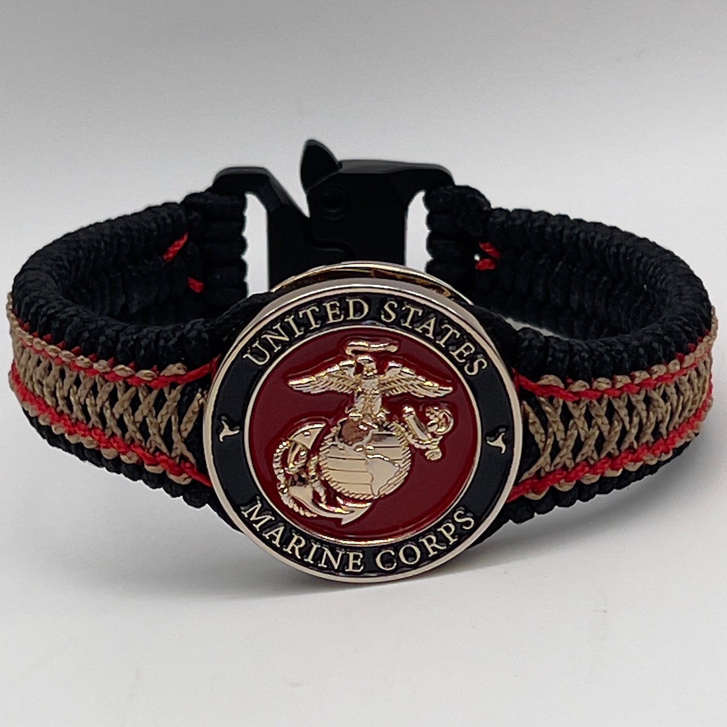 Thin, narrow, flexible and comfortable braided United States Marine Corps bracelet featuring a 24K gold plated USMC Eagle Globe and Anchor medallion, a black Cobra style tactical buckle and woven with black Type-1 paracord and Imperial Red and Gold nano cord.