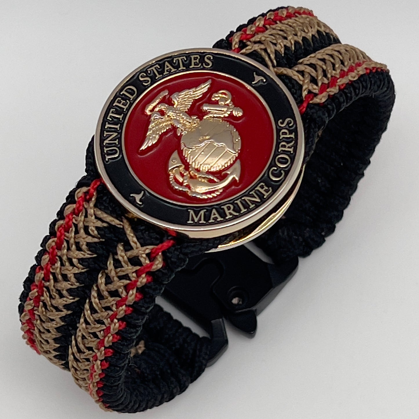 Thin, narrow, flexible and comfortable braided United States Marine Corps bracelet featuring a 24K gold plated USMC Eagle Globe and Anchor medallion, a black Cobra style tactical buckle and woven with black Type-1 paracord and Imperial Red and Gold nano cord.