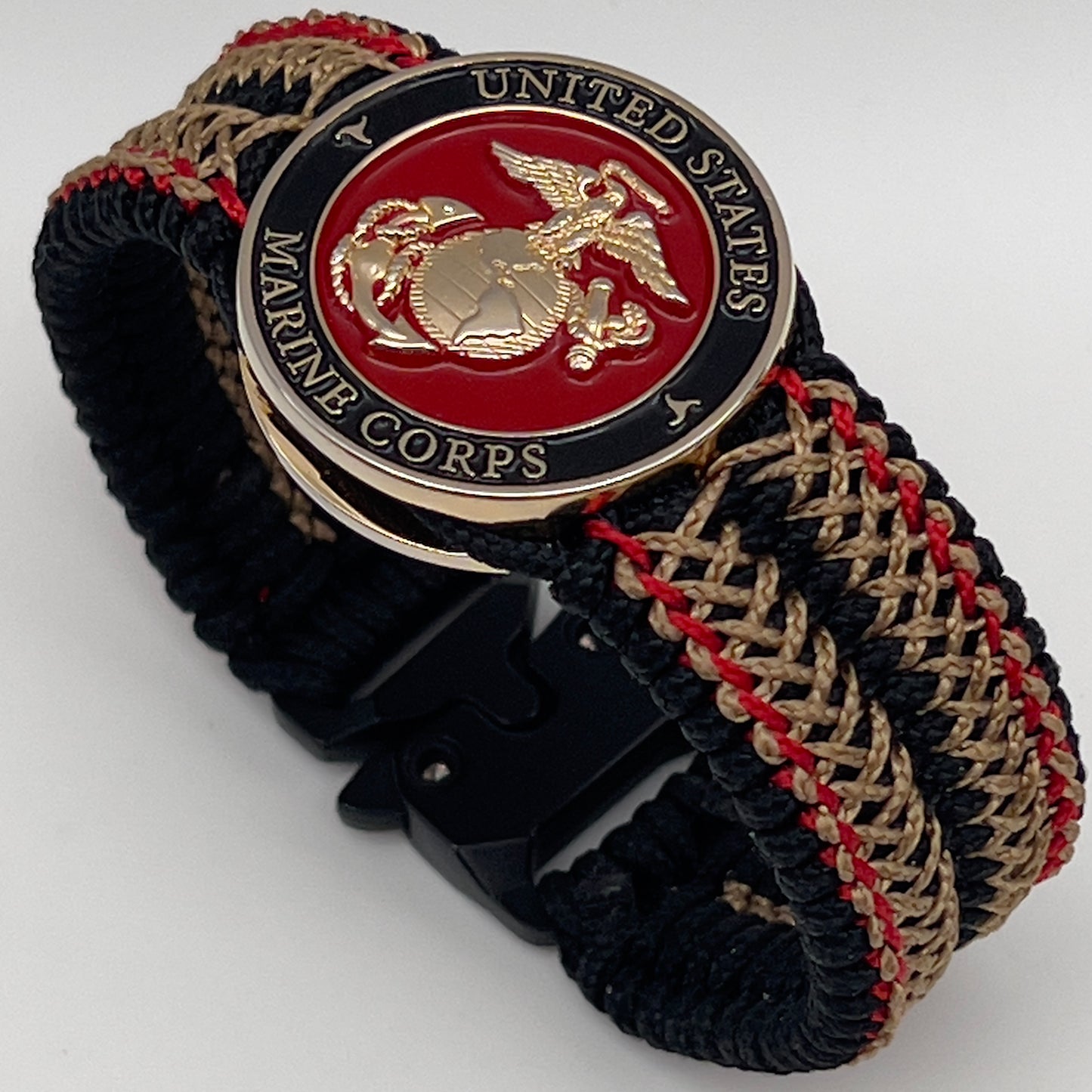 Thin, narrow, flexible and comfortable braided United States Marine Corps bracelet featuring a 24K gold plated USMC Eagle Globe and Anchor medallion, a black Cobra style tactical buckle and woven with black Type-1 paracord and Imperial Red and Gold nano cord.