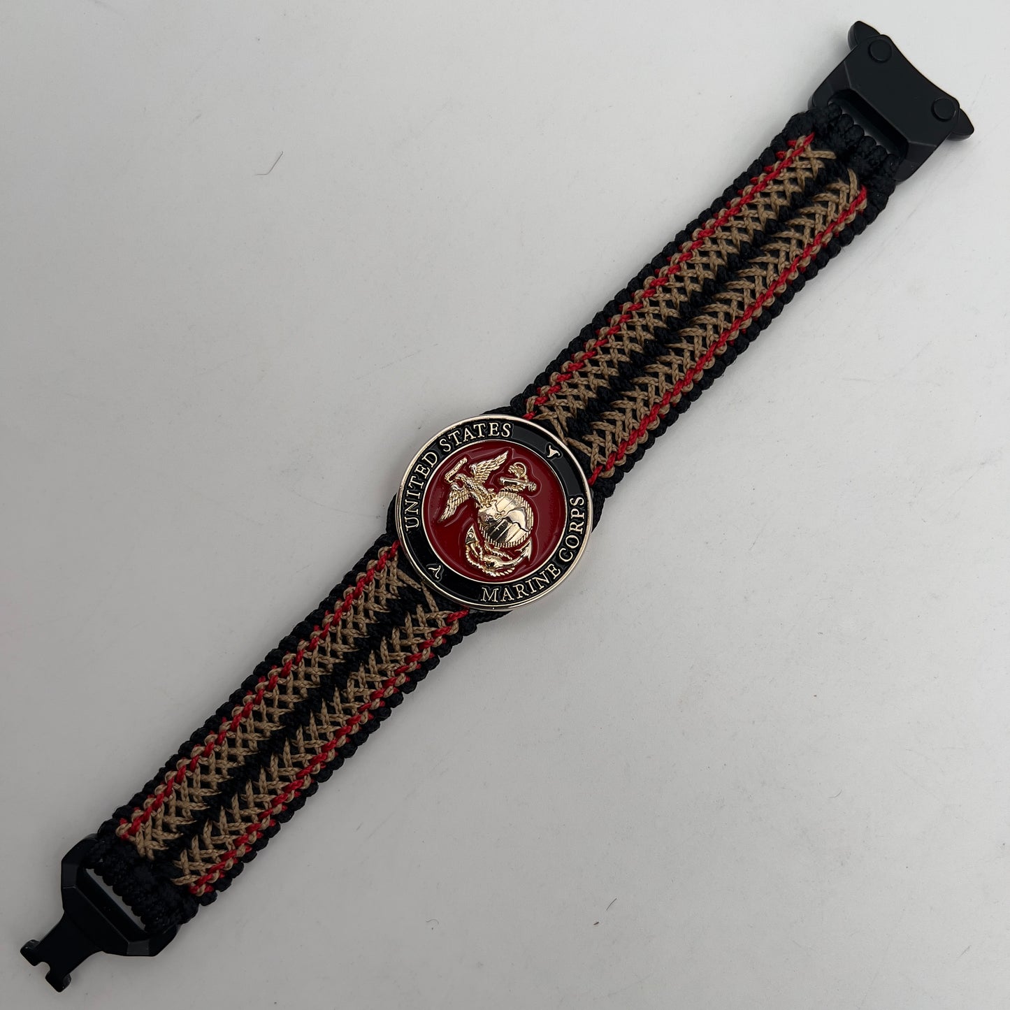 Thin, narrow, flexible and comfortable braided United States Marine Corps bracelet featuring a 24K gold plated USMC Eagle Globe and Anchor medallion, a black Cobra style tactical buckle and woven with black Type-1 paracord and Imperial Red and Gold nano cord.