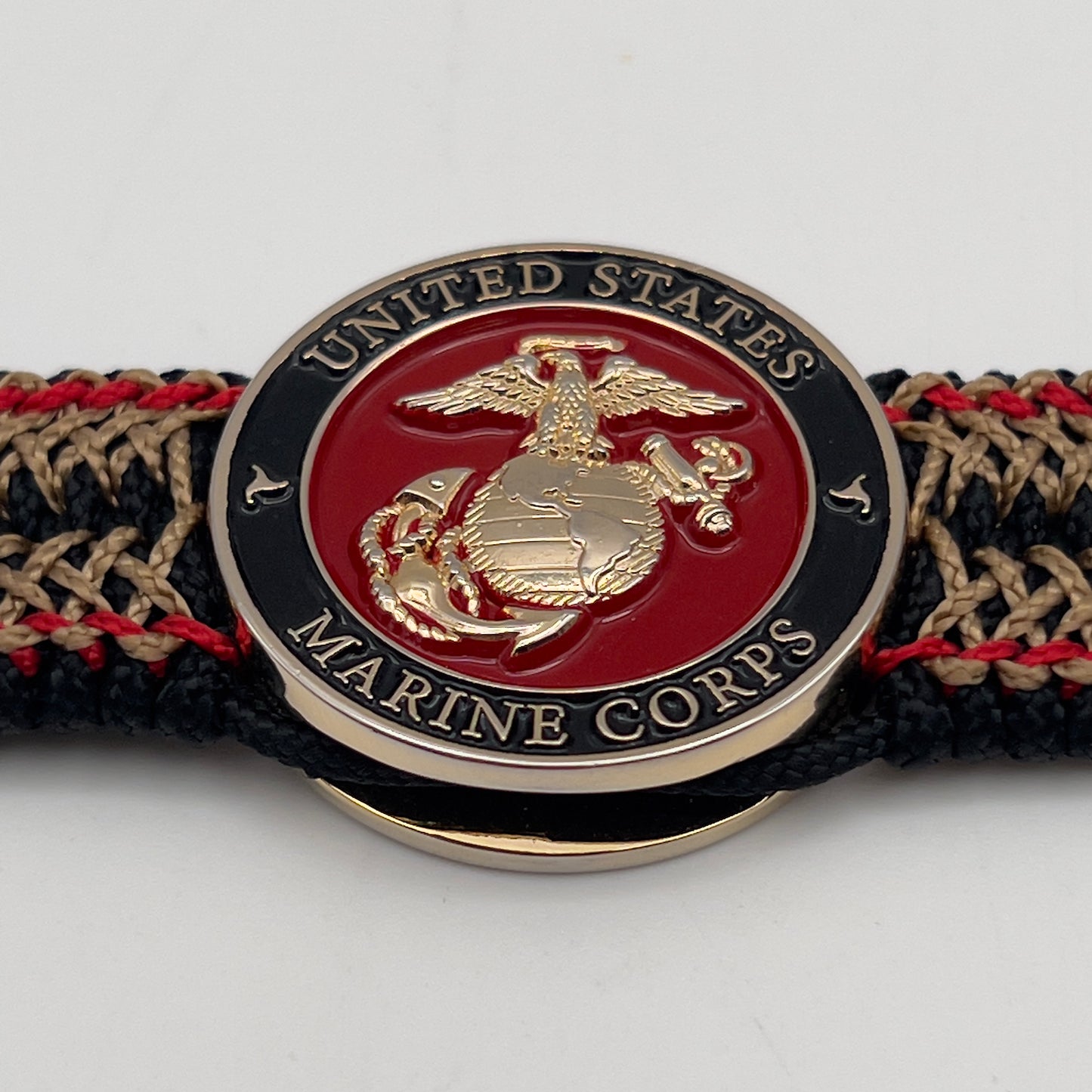 Thin, narrow, flexible and comfortable braided United States Marine Corps bracelet featuring a 24K gold plated USMC Eagle Globe and Anchor medallion, a black Cobra style tactical buckle and woven with black Type-1 paracord and Imperial Red and Gold nano cord.