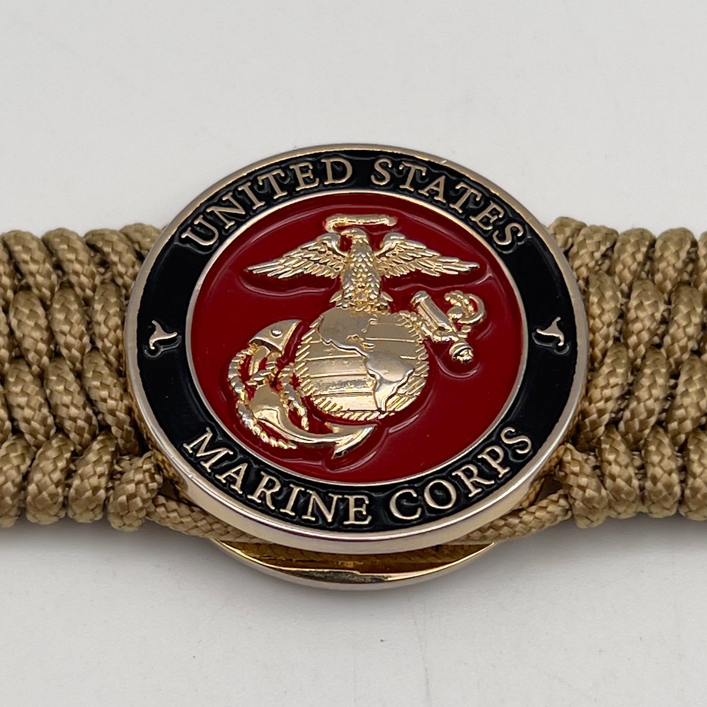 Thin, medium width, flexible and comfortable braided United States Marine Corps bracelet featuring a 24K gold plated USMC officer Eagle Globe and Anchor medallion, a gold Cobra style tactical buckle and woven with gold Type-1 paracord.