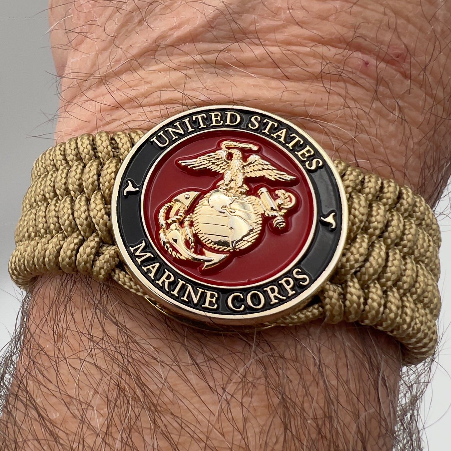 Thin, medium width, flexible and comfortable braided United States Marine Corps bracelet featuring a 24K gold plated USMC officer Eagle Globe and Anchor medallion, a gold Cobra style tactical buckle and woven with gold Type-1 paracord.