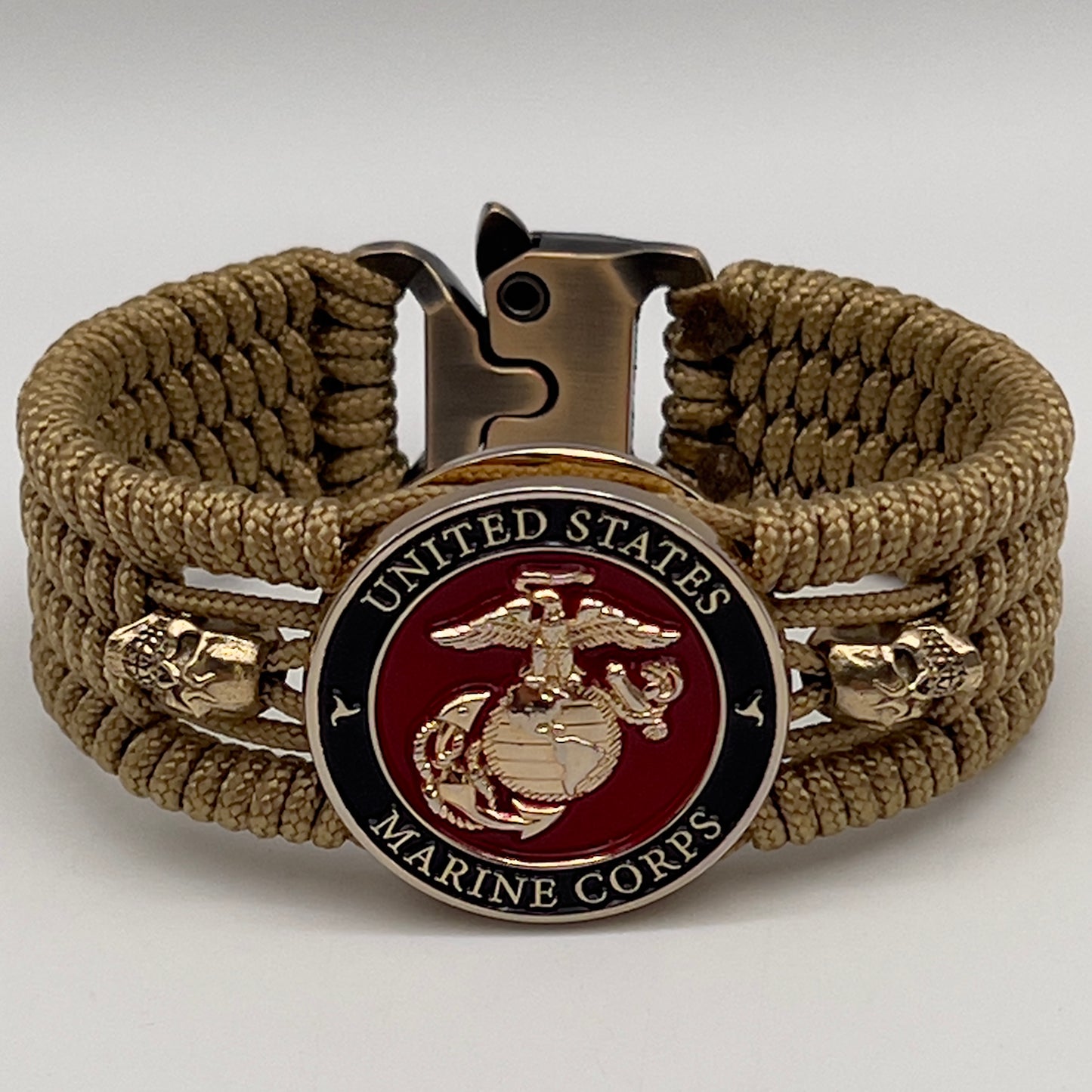 Thin, medium width, flexible and comfortable braided United States Marine Corps bracelet featuring a 24K gold plated USMC officer Eagle Globe and Anchor medallion, two gold plated skulls, a gold Cobra style tactical buckle and woven with gold Type-1 paracord.