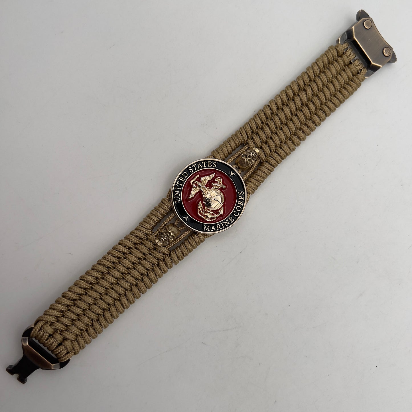 Thin, medium width, flexible and comfortable braided United States Marine Corps bracelet featuring a 24K gold plated USMC officer Eagle Globe and Anchor medallion, two gold plated skulls, a gold Cobra style tactical buckle and woven with gold Type-1 paracord.