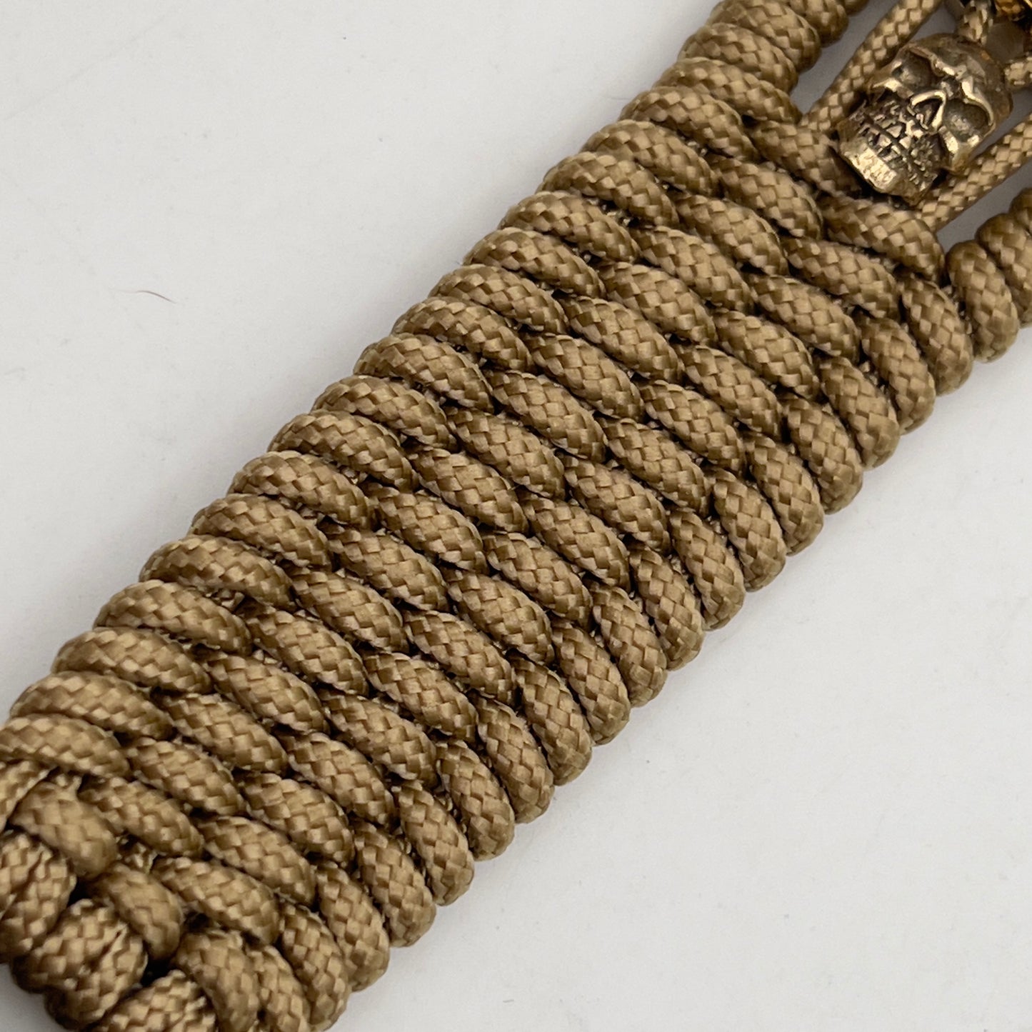 Thin, medium width, flexible and comfortable braided United States Marine Corps bracelet featuring a 24K gold plated USMC officer Eagle Globe and Anchor medallion, two gold plated skulls, a gold Cobra style tactical buckle and woven with gold Type-1 paracord.