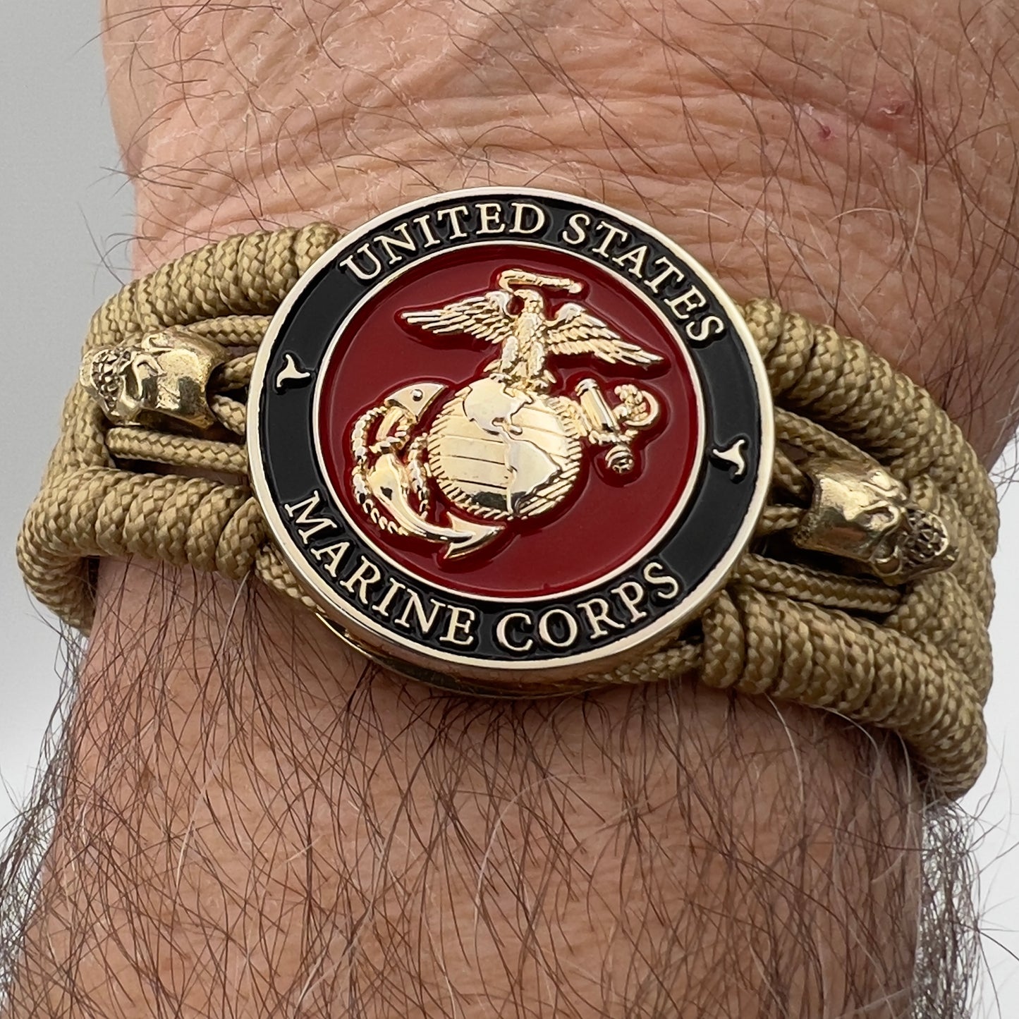 Thin, medium width, flexible and comfortable braided United States Marine Corps bracelet featuring a 24K gold plated USMC officer Eagle Globe and Anchor medallion, two gold plated skulls, a gold Cobra style tactical buckle and woven with gold Type-1 paracord.
