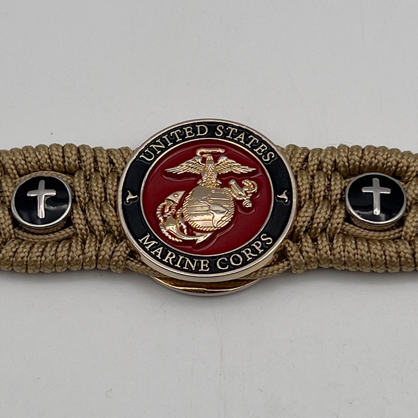 Thin, medium width, flexible and comfortable braided United States Marine Corps bracelet featuring a 24K gold plated USMC officer Eagle Globe and Anchor medallion, two Christian crosses, a gold Cobra style tactical buckle and woven with gold Type-1 paracord.