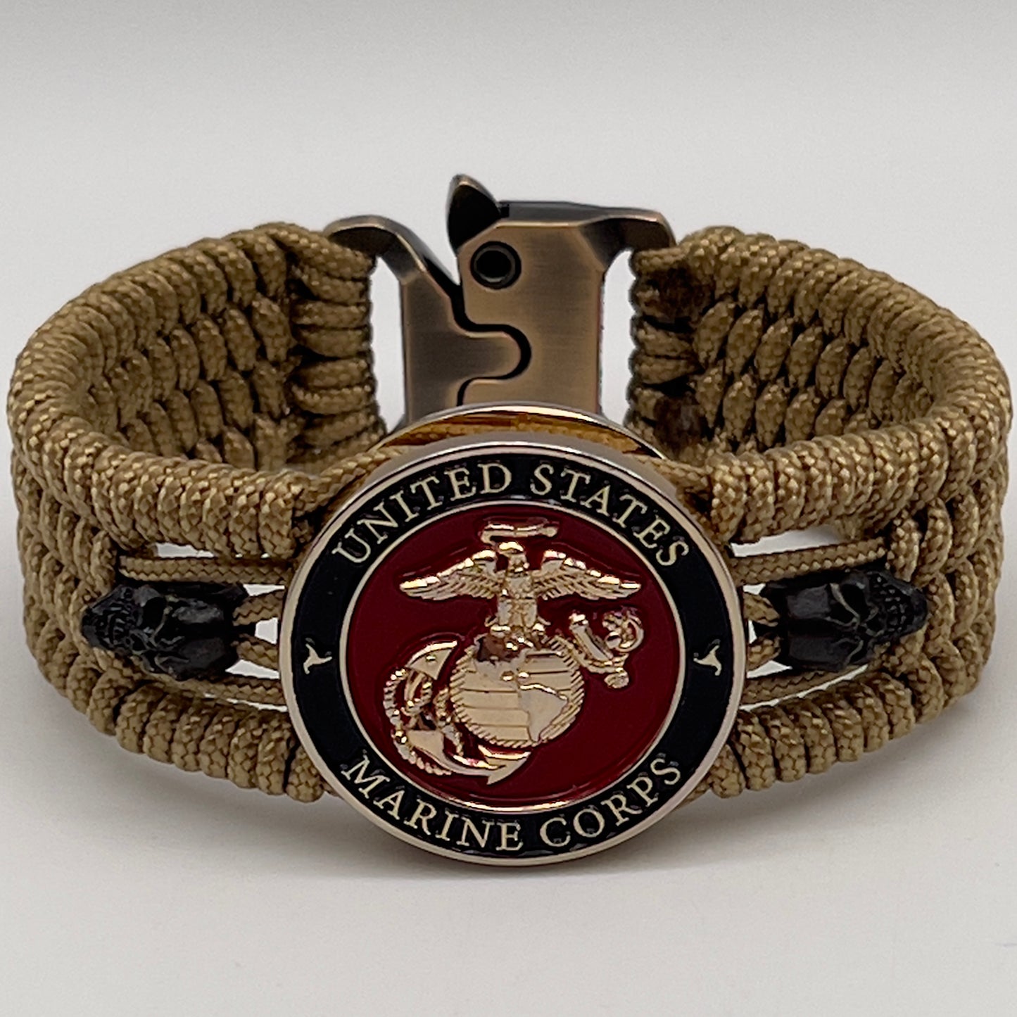 Thin, medium width, flexible and comfortable braided United States Marine Corps bracelet featuring a 24K gold plated USMC officer Eagle Globe and Anchor medallion, two black micro skulls, a gold Cobra style tactical buckle and woven with gold Type-1 paracord.