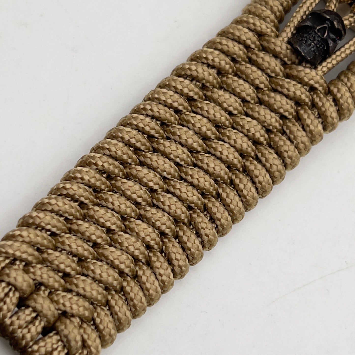 Thin, medium width, flexible and comfortable braided United States Marine Corps bracelet featuring a 24K gold plated USMC officer Eagle Globe and Anchor medallion, two black micro skulls, a gold Cobra style tactical buckle and woven with gold Type-1 paracord.