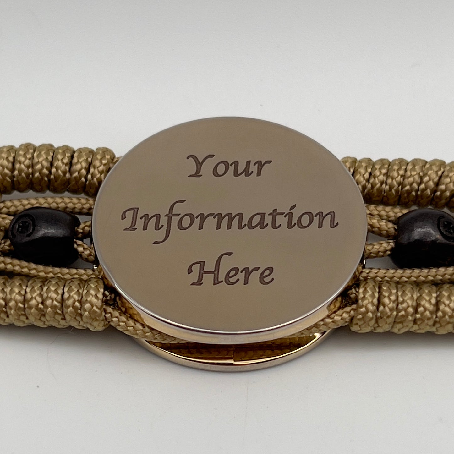 Thin, medium width, flexible and comfortable braided United States Marine Corps bracelet featuring a 24K gold plated USMC officer Eagle Globe and Anchor medallion, two black micro skulls, a gold Cobra style tactical buckle and woven with gold Type-1 paracord.