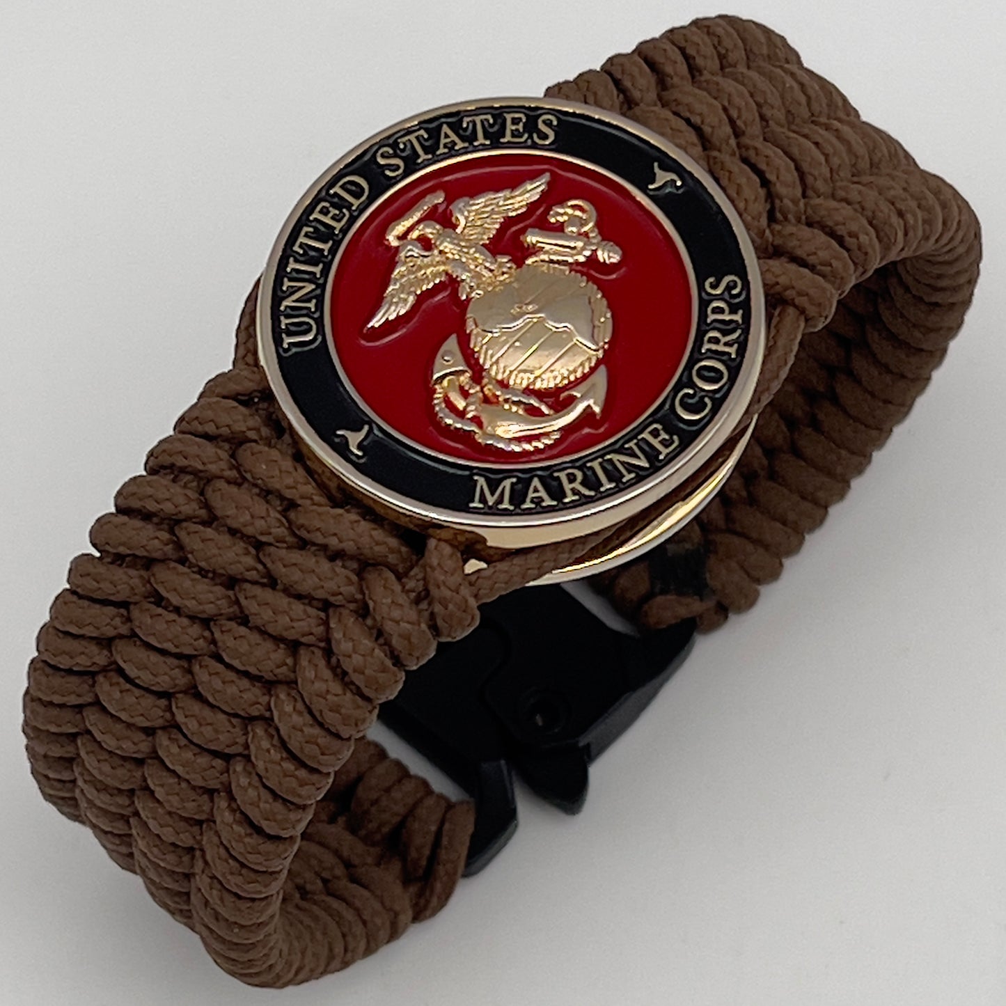 Thin, medium width, flexible and comfortable braided United States Marine Corps bracelet featuring a 24K gold plated USMC officer Eagle Globe and Anchor medallion, a gold Cobra style tactical buckle and woven with Coyote Brown Type-1 paracord.
