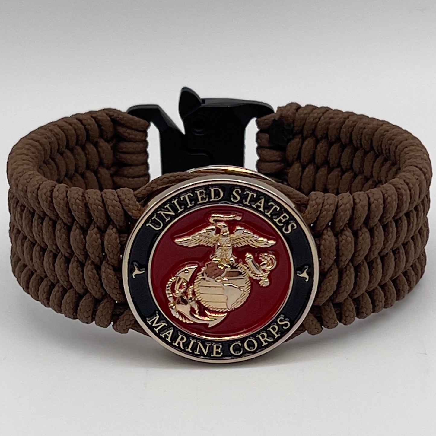 Thin, medium width, flexible and comfortable braided United States Marine Corps bracelet featuring a 24K gold plated USMC officer Eagle Globe and Anchor medallion, a gold Cobra style tactical buckle and woven with Coyote Brown Type-1 paracord.