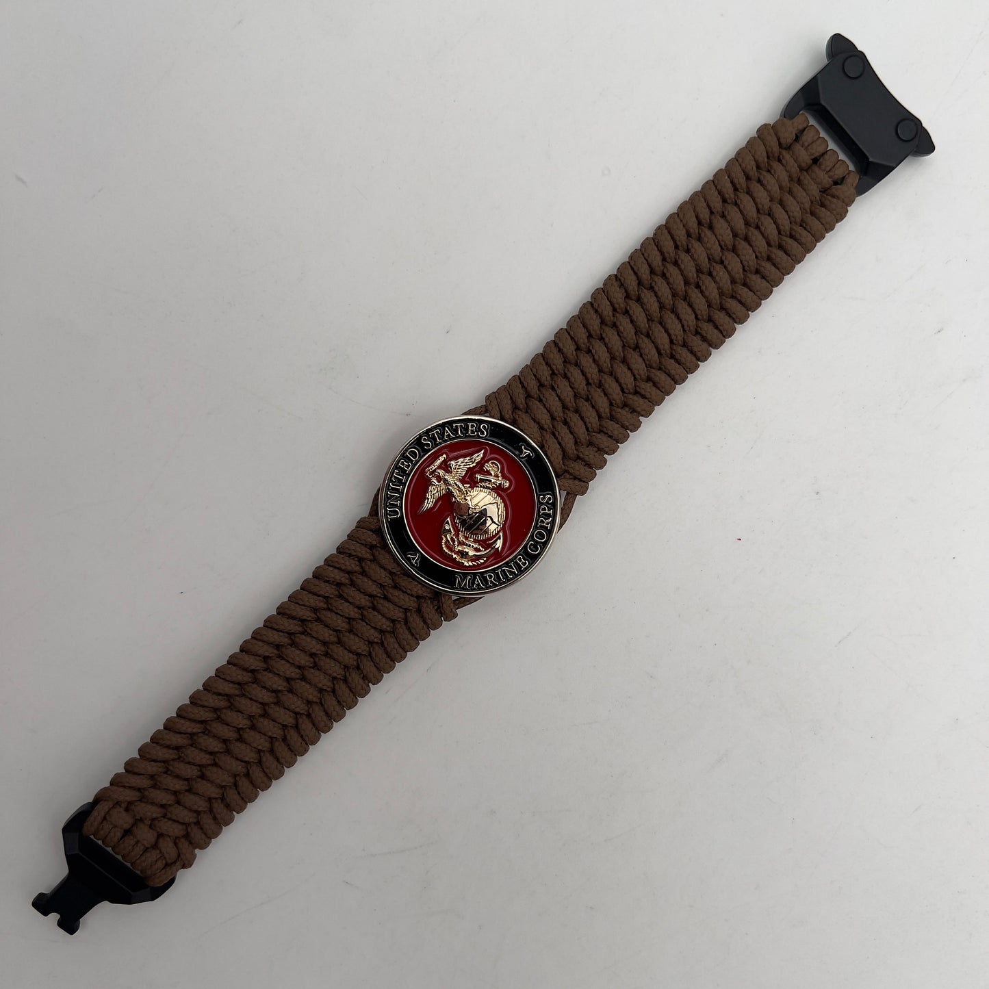 Thin, medium width, flexible and comfortable braided United States Marine Corps bracelet featuring a 24K gold plated USMC officer Eagle Globe and Anchor medallion, a gold Cobra style tactical buckle and woven with Coyote Brown Type-1 paracord.