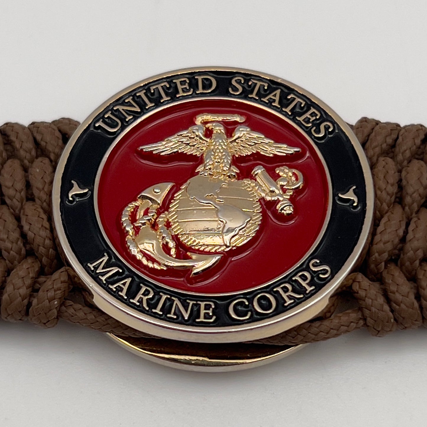 Thin, medium width, flexible and comfortable braided United States Marine Corps bracelet featuring a 24K gold plated USMC officer Eagle Globe and Anchor medallion, a gold Cobra style tactical buckle and woven with Coyote Brown Type-1 paracord.
