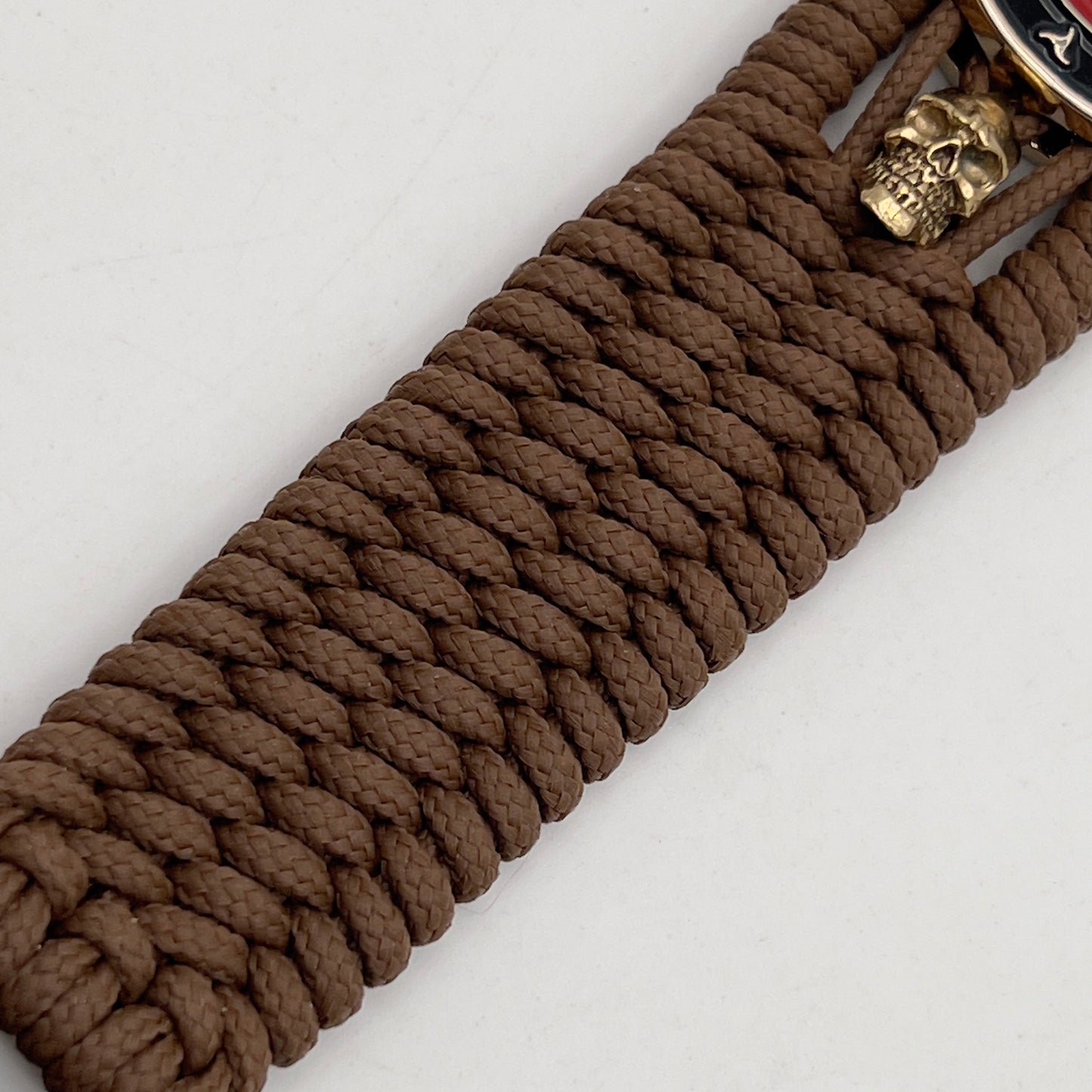 Thin, medium width, flexible and comfortable braided United States Marine Corps bracelet featuring a 24K gold plated USMC officer Eagle Globe and Anchor medallion, two gold plated skulls, a gold Cobra style tactical buckle and woven with Coyote Brown Type-1 paracord.