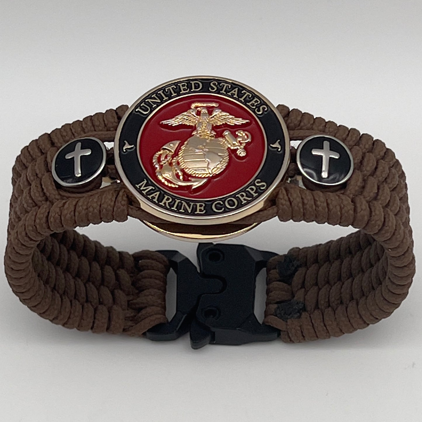 Thin, medium width, flexible and comfortable braided United States Marine Corps bracelet featuring a 24K gold plated USMC officer Eagle Globe and Anchor medallion, two Christian crosses, a black Cobra style tactical buckle and woven with Coyote Brown Type-1 paracord.