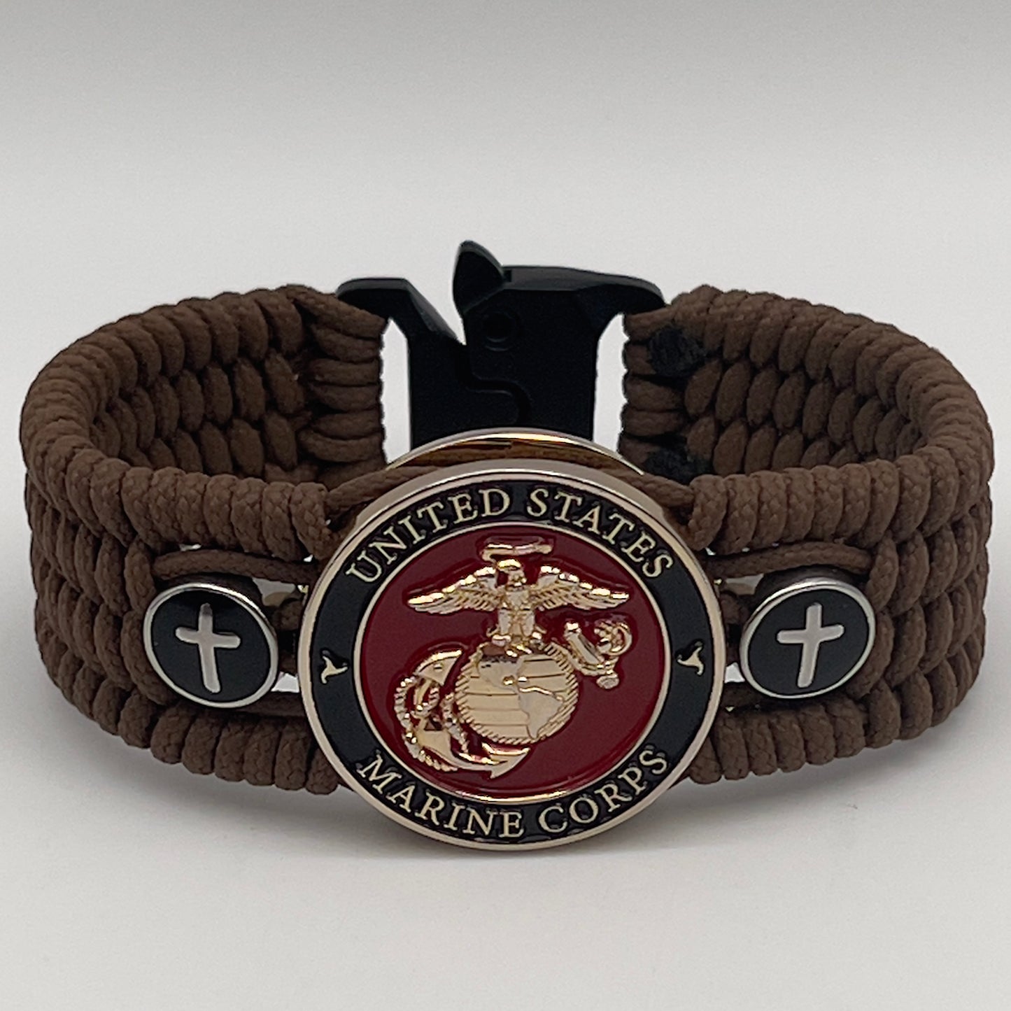 Thin, medium width, flexible and comfortable braided United States Marine Corps bracelet featuring a 24K gold plated USMC officer Eagle Globe and Anchor medallion, two Christian crosses, a black Cobra style tactical buckle and woven with Coyote Brown Type-1 paracord.