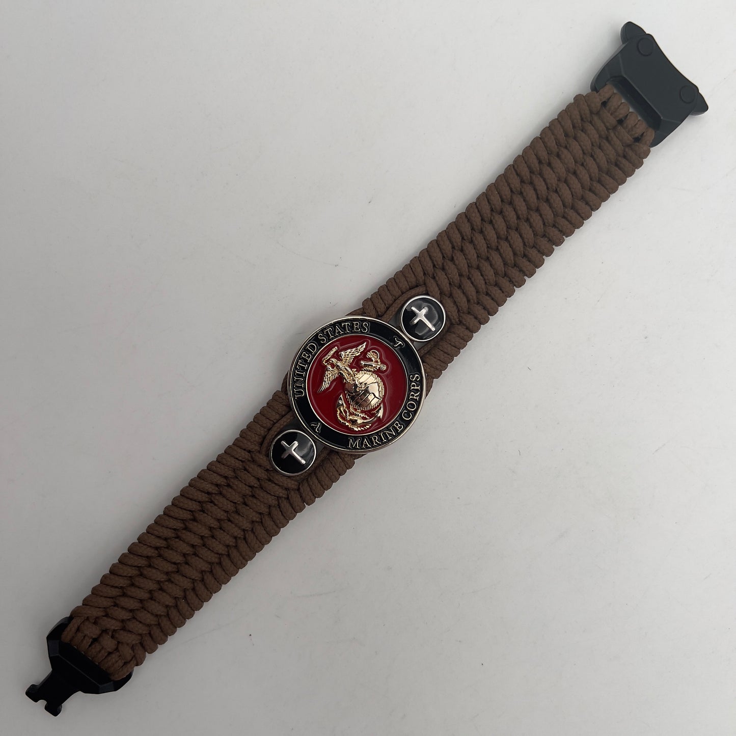 Thin, medium width, flexible and comfortable braided United States Marine Corps bracelet featuring a 24K gold plated USMC officer Eagle Globe and Anchor medallion, two Christian crosses, a black Cobra style tactical buckle and woven with Coyote Brown Type-1 paracord.