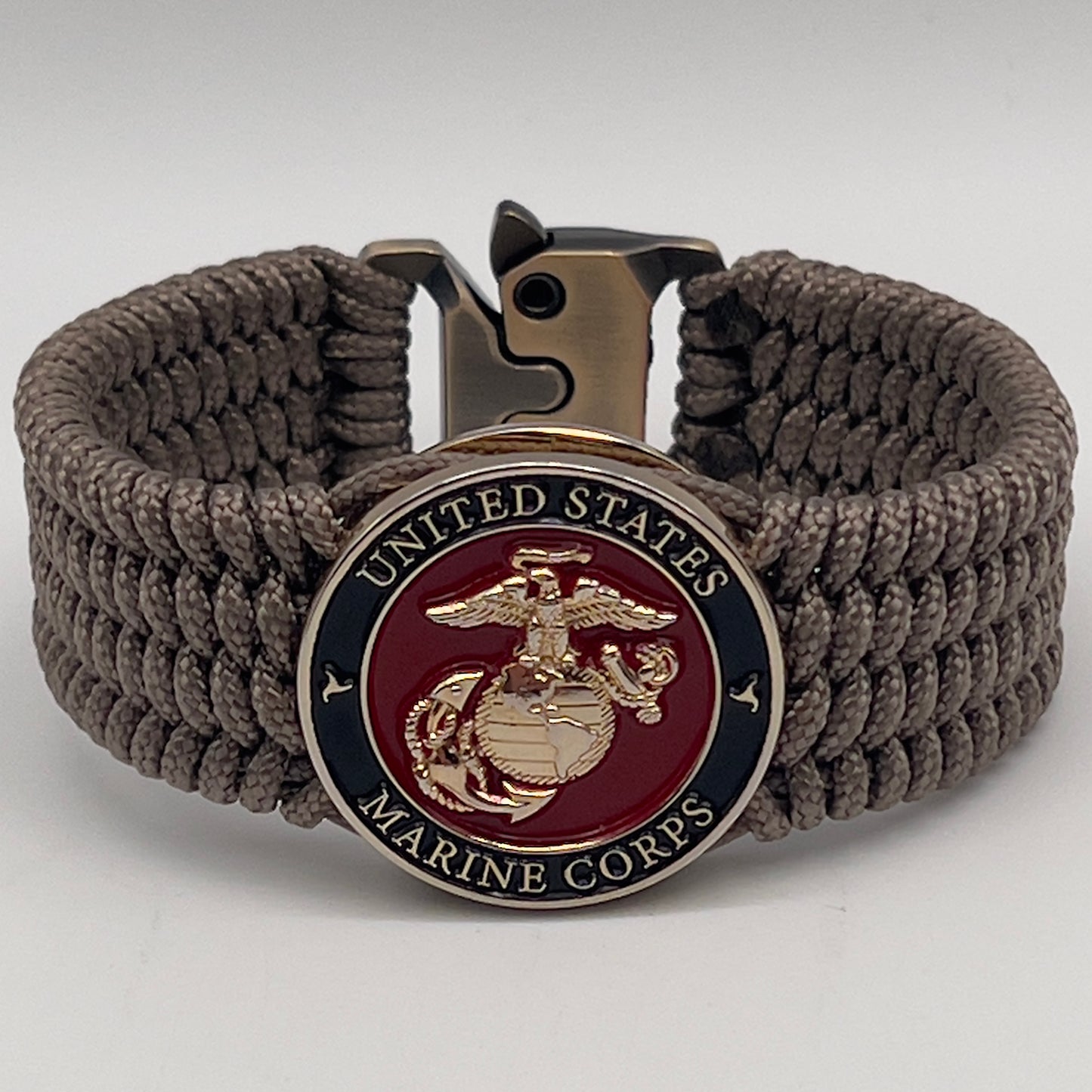 Thin, medium width, flexible and comfortable braided United States Marine Corps bracelet featuring a 24K gold plated USMC officer Eagle Globe and Anchor medallion, a gold Cobra style tactical buckle and woven with Tan Type-1 paracord.