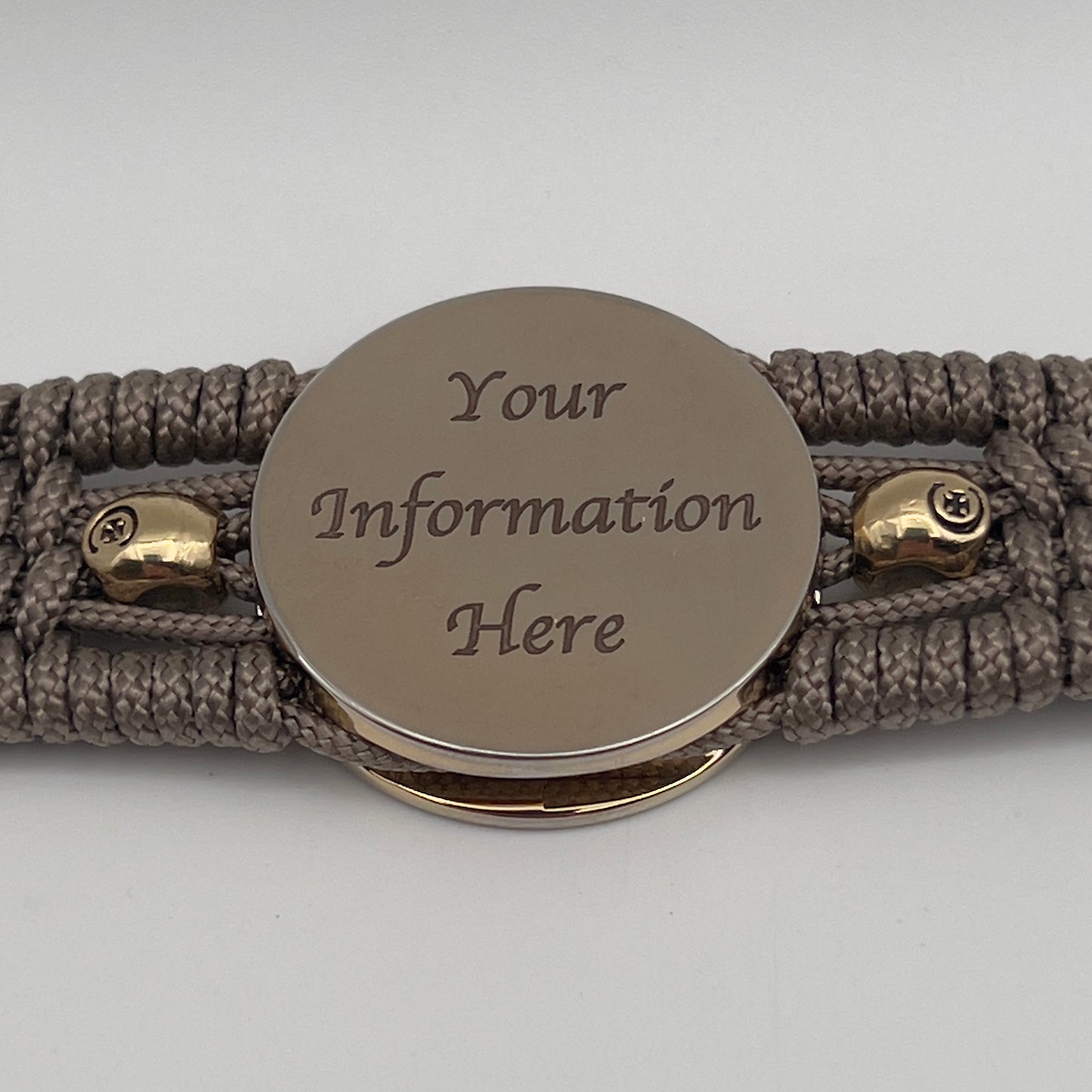 Thin, medium width, flexible and comfortable braided United States Marine Corps bracelet featuring a 24K gold plated USMC officer Eagle Globe and Anchor medallion, two gold plated skulls, a gold Cobra style tactical buckle and woven with Tan Type-1 paracord.