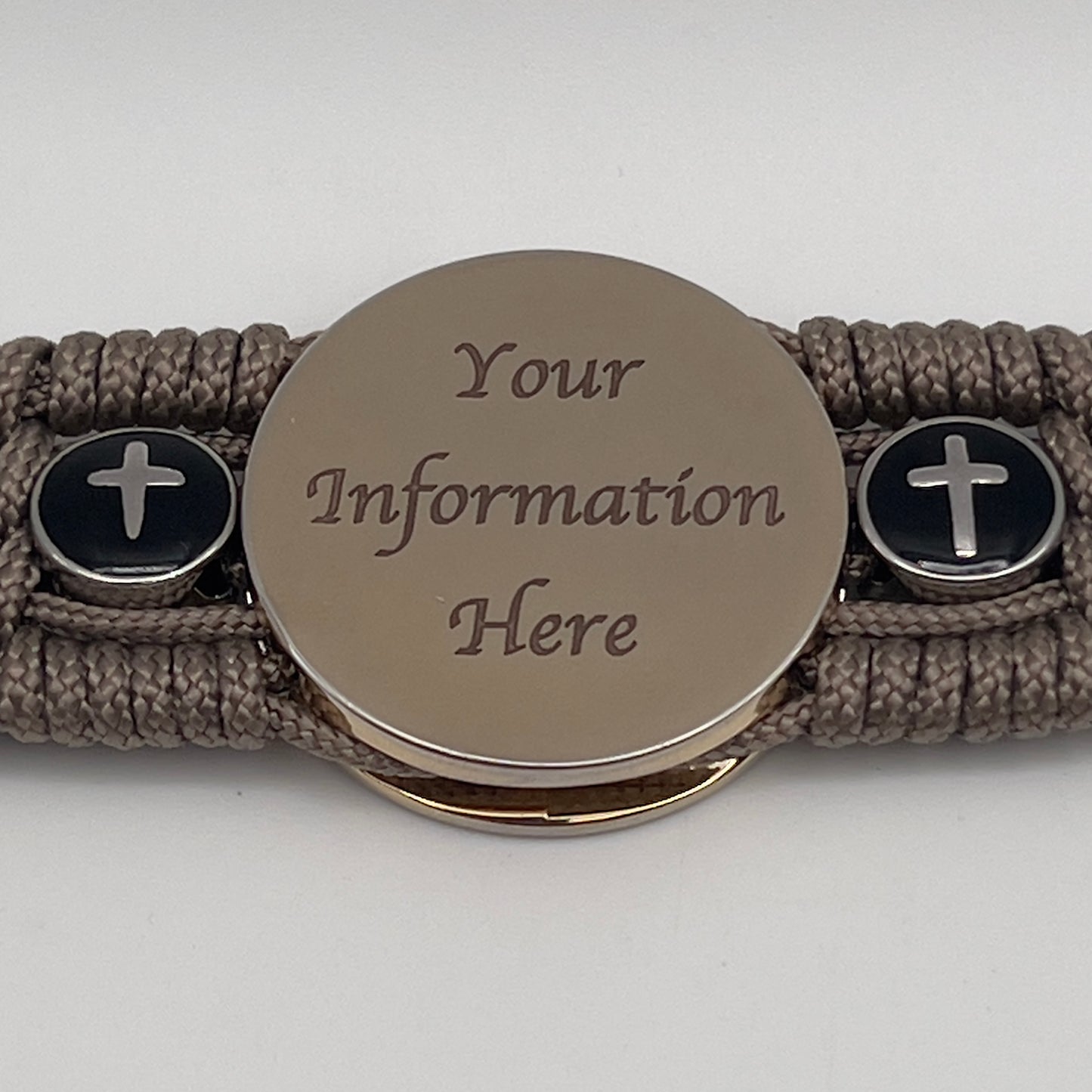 Thin, medium width, flexible and comfortable braided United States Marine Corps bracelet featuring a 24K gold plated USMC officer Eagle Globe and Anchor medallion, two Christian crosses, a black Cobra style tactical buckle and woven with Tan Type-1 paracord.