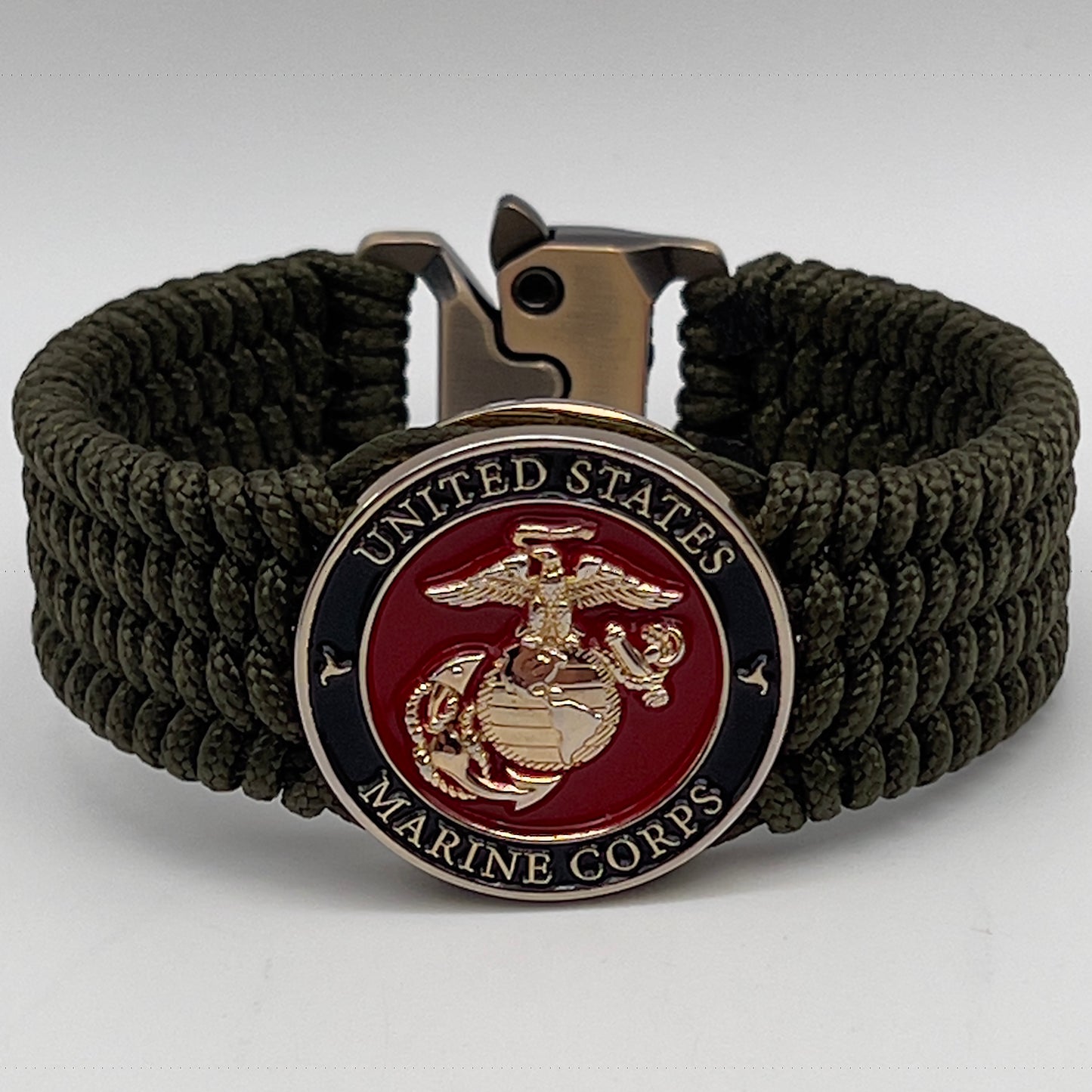 Thin, medium width, flexible and comfortable braided United States Marine Corps bracelet featuring a 24K gold plated USMC officer Eagle Globe and Anchor medallion, a gold Cobra style tactical buckle and woven with Olive Drab Type-1 paracord.