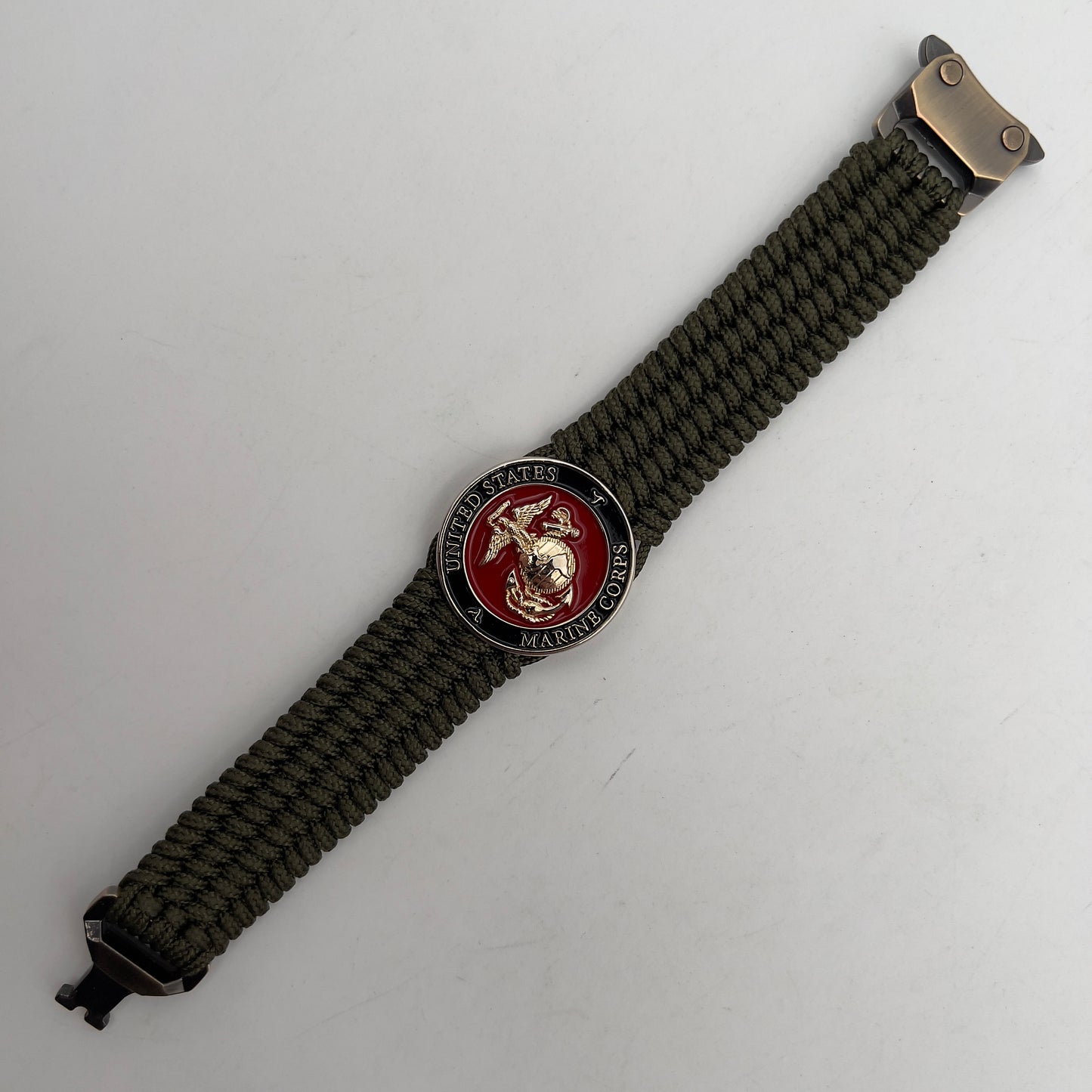Thin, medium width, flexible and comfortable braided United States Marine Corps bracelet featuring a 24K gold plated USMC officer Eagle Globe and Anchor medallion, a gold Cobra style tactical buckle and woven with Olive Drab Type-1 paracord.