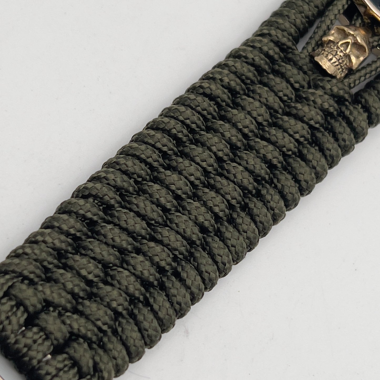 Thin, medium width, flexible and comfortable braided United States Marine Corps bracelet featuring a 24K gold plated USMC officer Eagle Globe and Anchor medallion, two gold plated skulls, a gold Cobra style tactical buckle and woven with Olive Drab Type-1 paracord.
