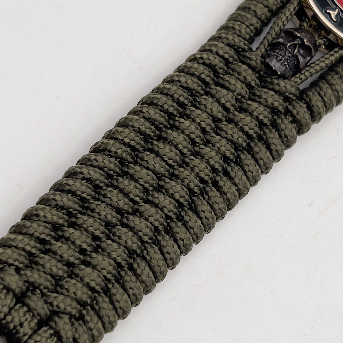 Thin, medium width, flexible and comfortable braided United States Marine Corps bracelet featuring a 24K gold plated USMC officer Eagle Globe and Anchor medallion, two black micro skulls, a black Cobra style tactical buckle and woven with Olive Drab Type-1 paracord.