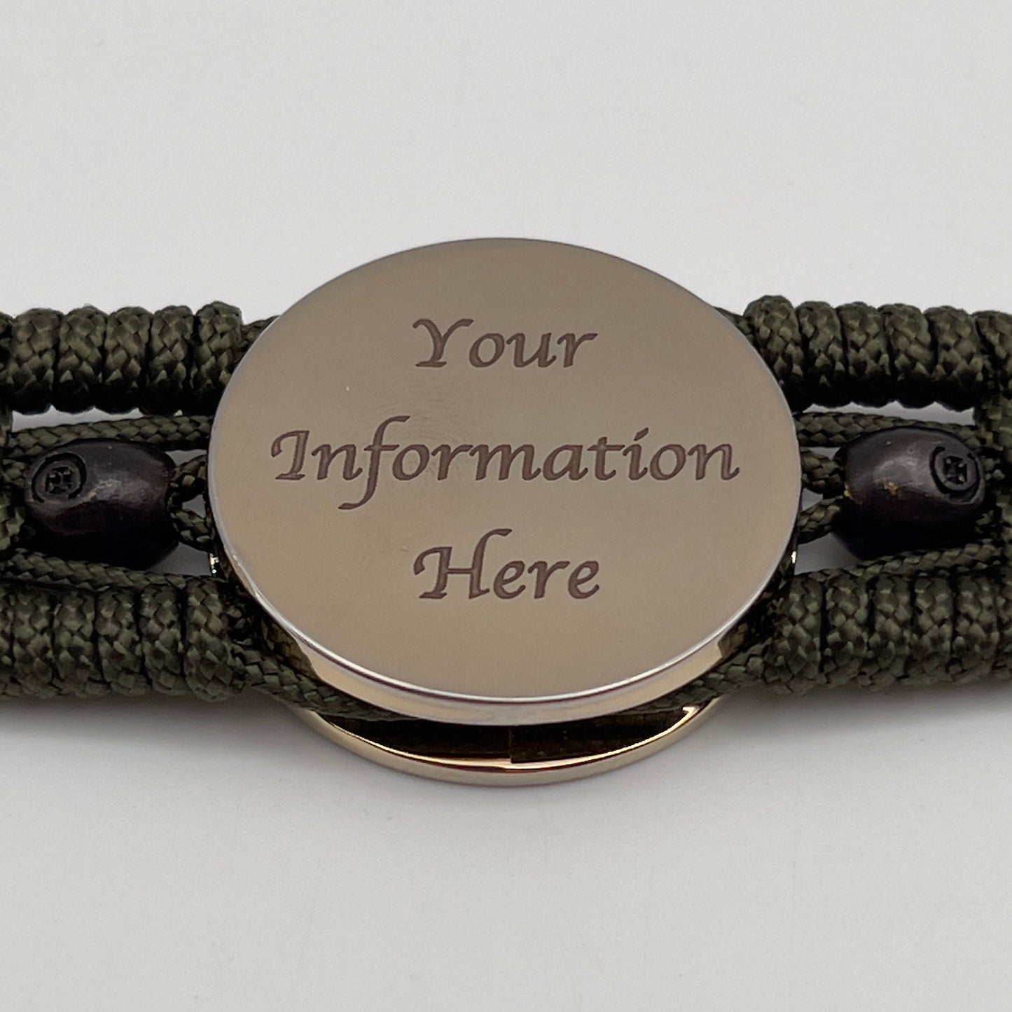 Thin, medium width, flexible and comfortable braided United States Marine Corps bracelet featuring a 24K gold plated USMC officer Eagle Globe and Anchor medallion, two black micro skulls, a black Cobra style tactical buckle and woven with Olive Drab Type-1 paracord.