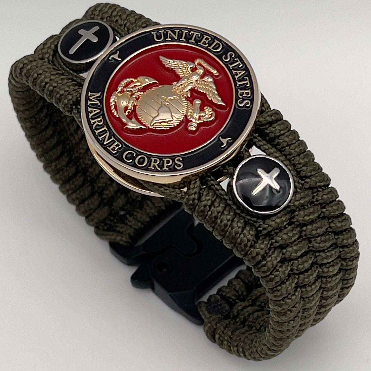 Thin, medium width, flexible and comfortable braided United States Marine Corps bracelet featuring a 24K gold plated USMC officer Eagle Globe and Anchor medallion, two Christian crosses, a black Cobra style tactical buckle and woven with Olive Drab Type-1 paracord.