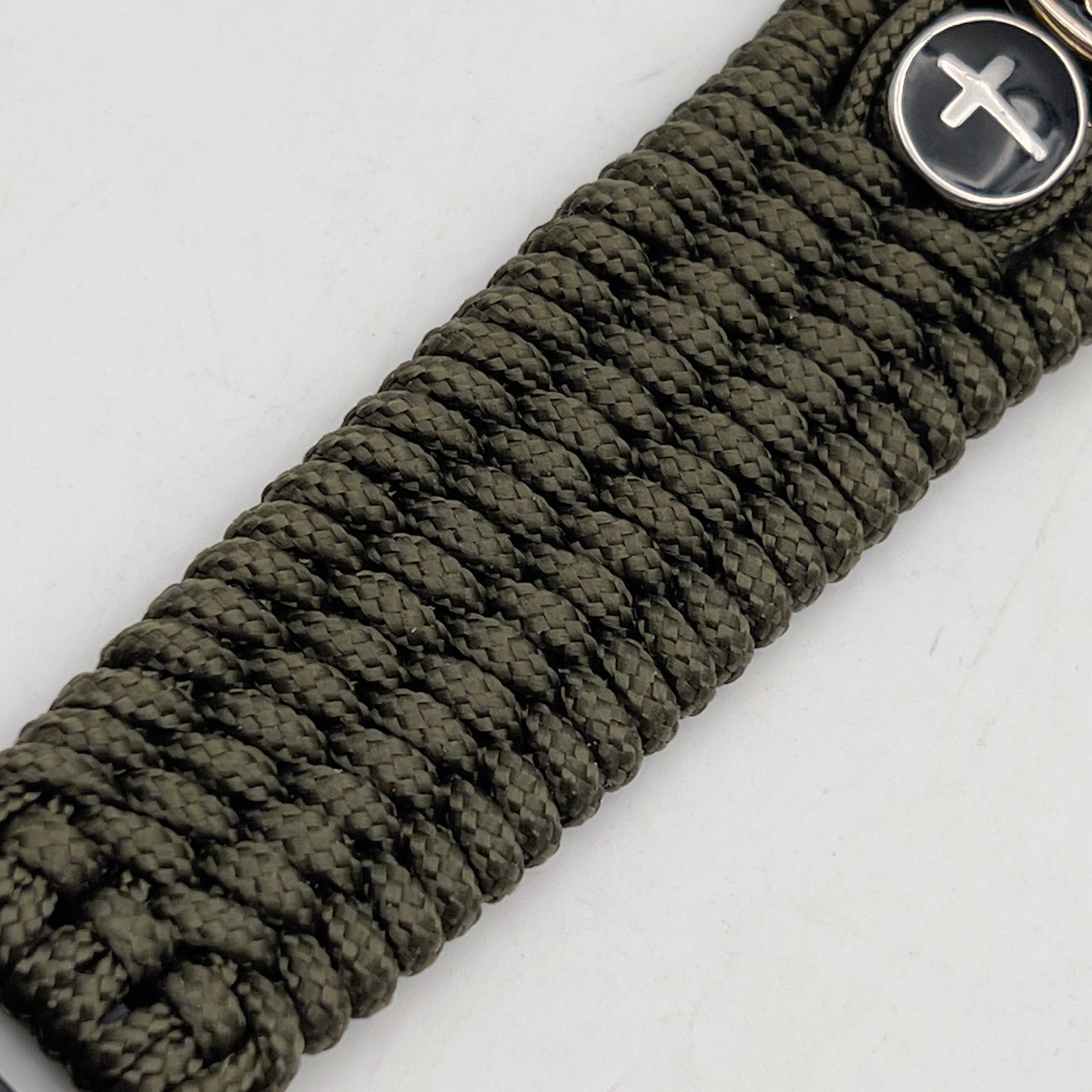 Thin, medium width, flexible and comfortable braided United States Marine Corps bracelet featuring a 24K gold plated USMC officer Eagle Globe and Anchor medallion, two Christian crosses, a black Cobra style tactical buckle and woven with Olive Drab Type-1 paracord.