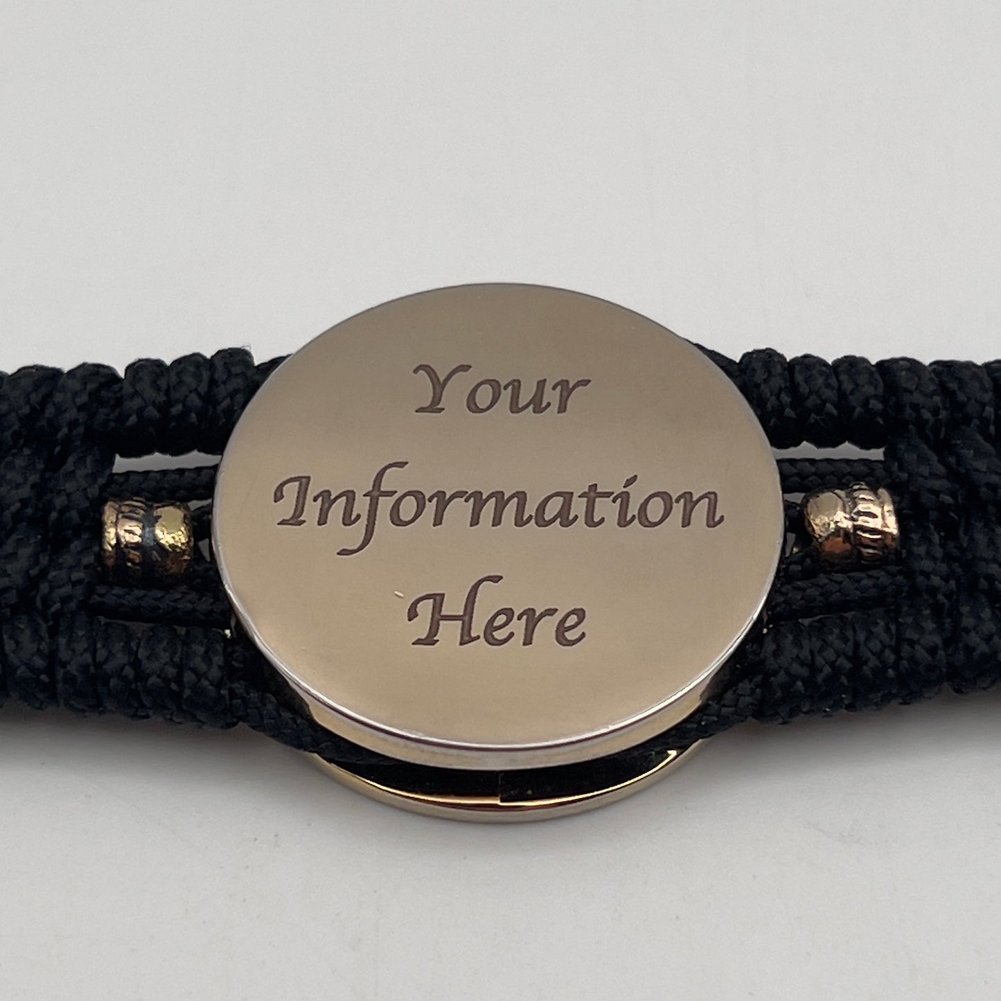 Thin, medium width, flexible and comfortable braided United States Marine Corps bracelet featuring a 24K gold plated USMC officer Eagle Globe and Anchor medallion, two brass Spartan helmets, a black Cobra style tactical buckle and woven with black Type-1 paracord.