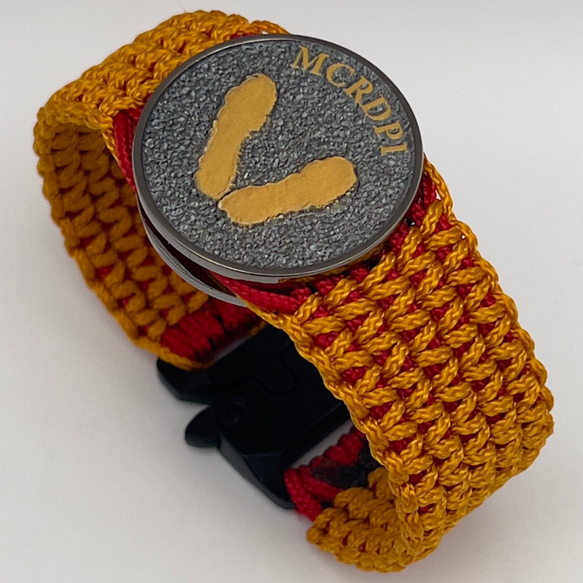 Thin, narrow, flexible and comfortable braided United States Marine Corps Recruit Depot Yellow Footprints bracelet featuring a black nickel plated UV enamel painted medallion replica of an actual set of USMC footprints, a black Cobra style tactical buckle and woven with Imperial Red type-1 paracord and Goldenrod micro cord.