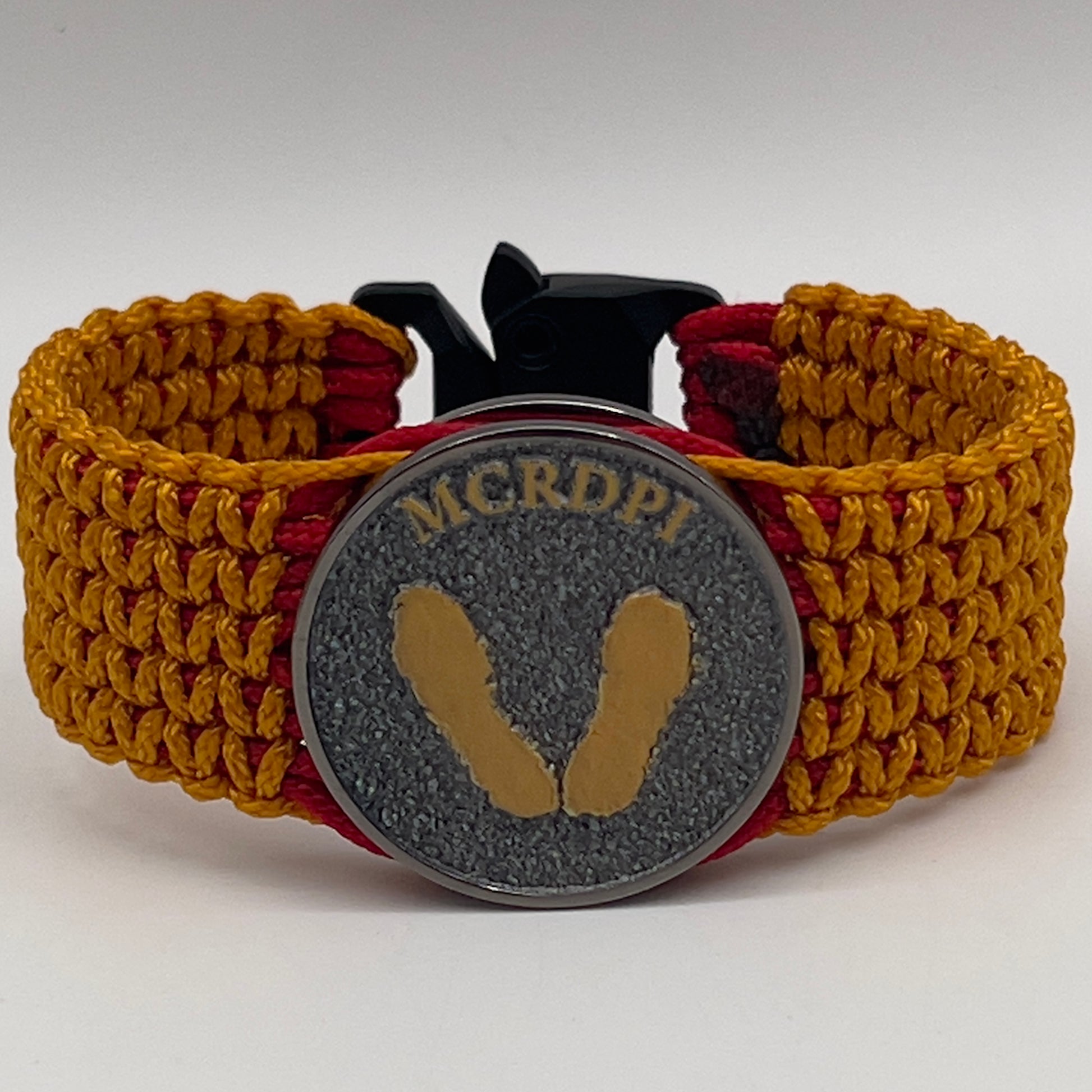 Thin, narrow, flexible and comfortable braided United States Marine Corps Recruit Depot Yellow Footprints bracelet featuring a black nickel plated UV enamel painted medallion replica of an actual set of USMC footprints, a black Cobra style tactical buckle and woven with Imperial Red type-1 paracord and Goldenrod micro cord.