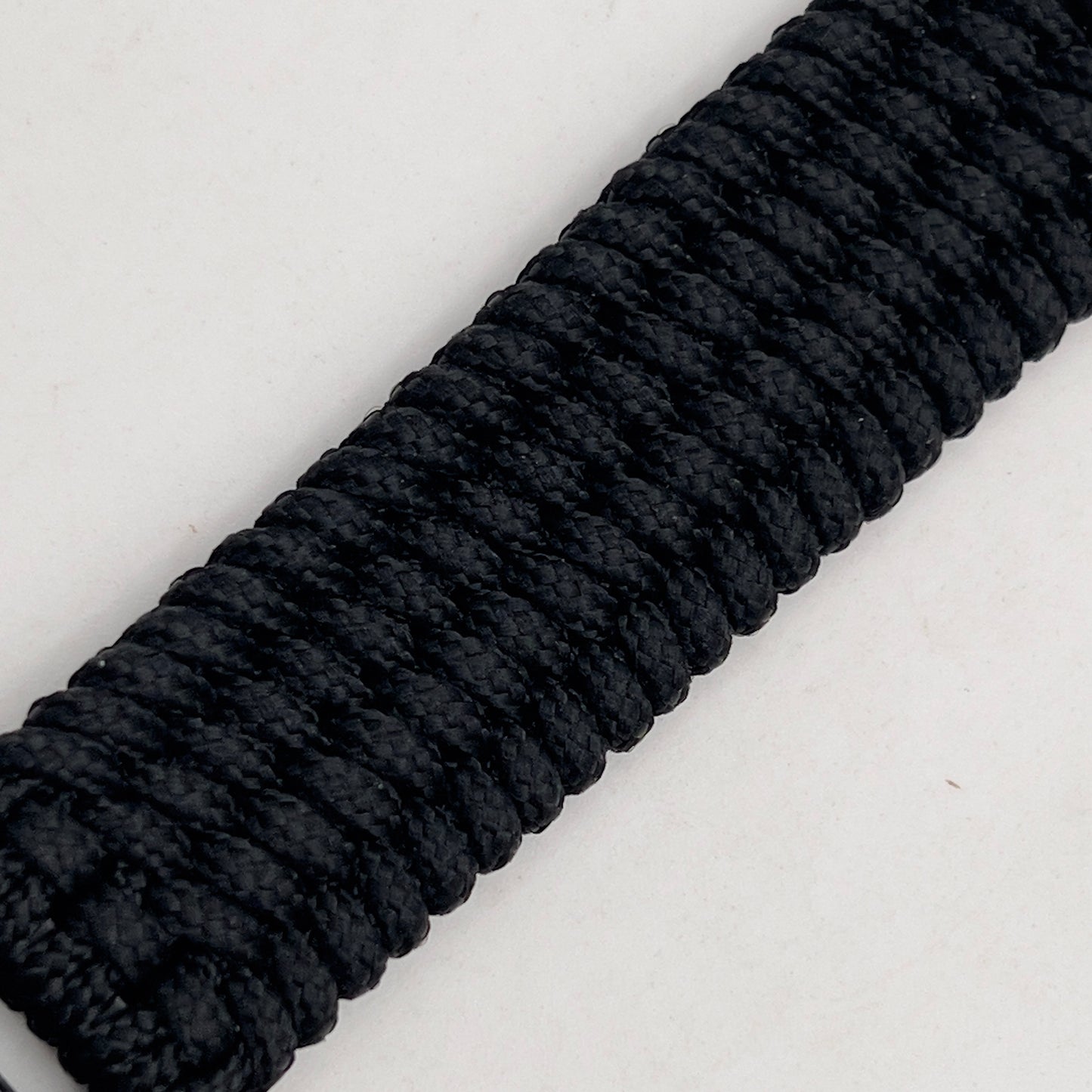 Thin, wide, flexible and comfortable braided United States Marine Corps Recruit Depot Yellow Footprints bracelet featuring a black nickel plated UV enamel painted medallion replica of an actual set of USMC footprints, a black Cobra style tactical buckle and woven with black Type-1 paracord.