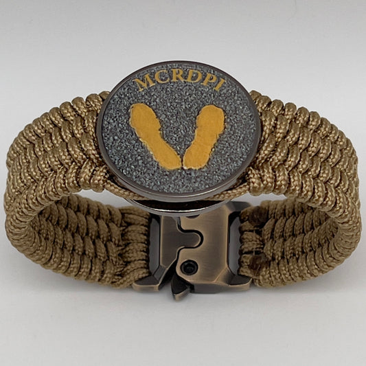 Thin, wide, flexible and comfortable braided United States Marine Corps Recruit Depot Yellow Footprints bracelet featuring a black nickel plated UV enamel painted medallion replica of an actual set of USMC footprints, a gold Cobra style tactical buckle and woven with gold Type-1 paracord.