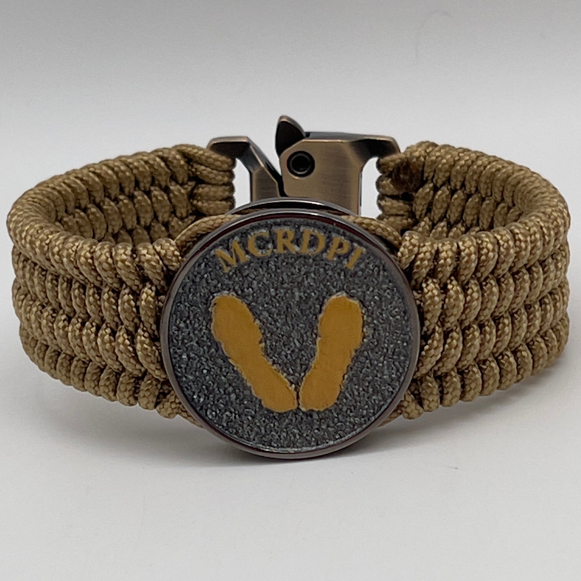 Thin, wide, flexible and comfortable braided United States Marine Corps Recruit Depot Yellow Footprints bracelet featuring a black nickel plated UV enamel painted medallion replica of an actual set of USMC footprints, a gold Cobra style tactical buckle and woven with gold Type-1 paracord.