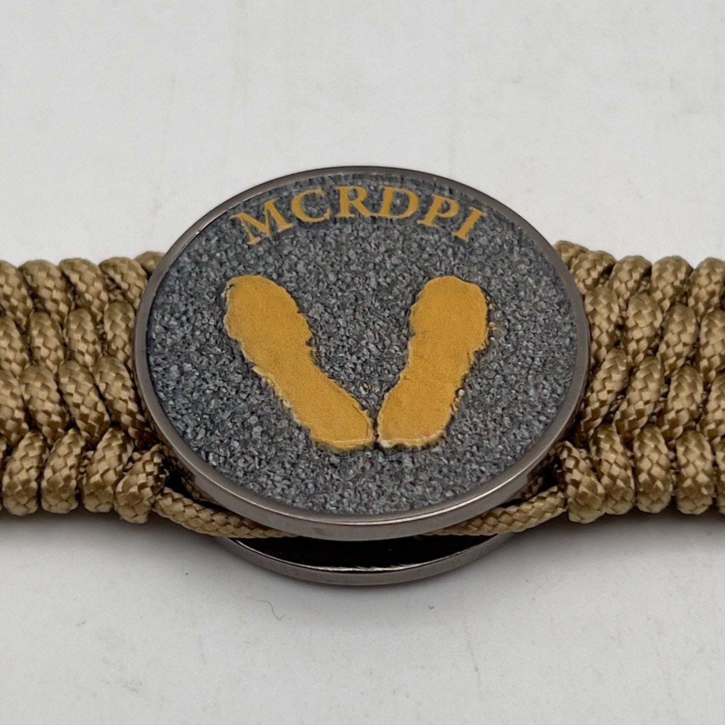 Thin, wide, flexible and comfortable braided United States Marine Corps Recruit Depot Yellow Footprints bracelet featuring a black nickel plated UV enamel painted medallion replica of an actual set of USMC footprints, a gold Cobra style tactical buckle and woven with gold Type-1 paracord.